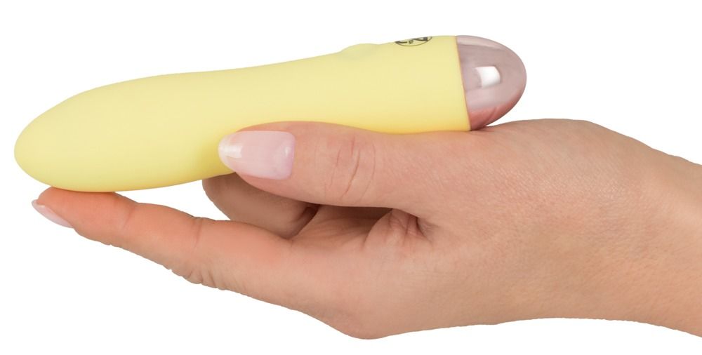 Hand hält einen gelben Mini-Vibrator mit rosa Spitze.