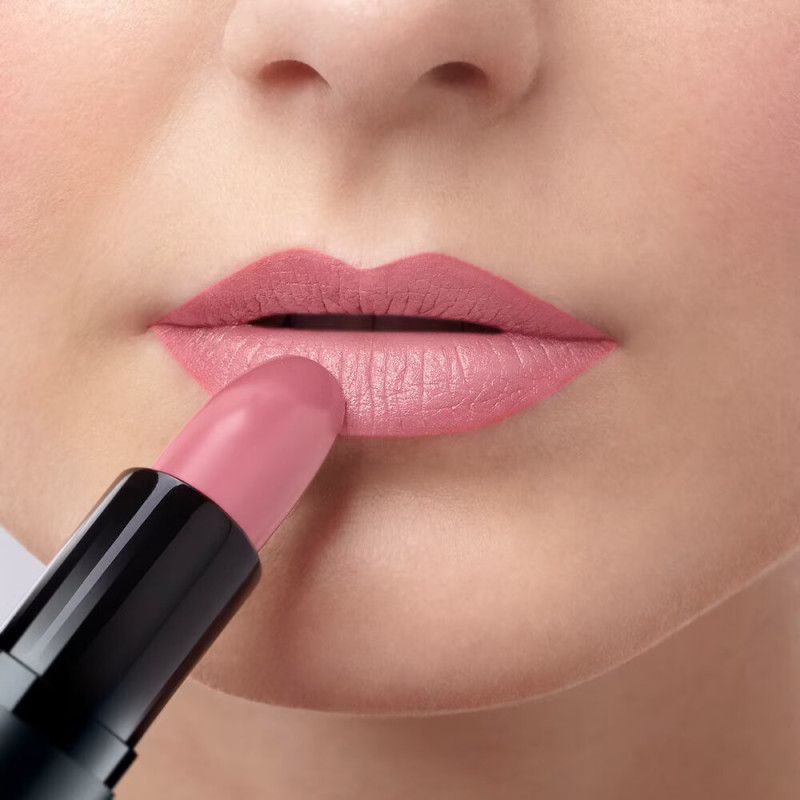 Nahaufnahme von Lippen, auf die mit einem hellrosa Lippenstift aufgetragen wird.