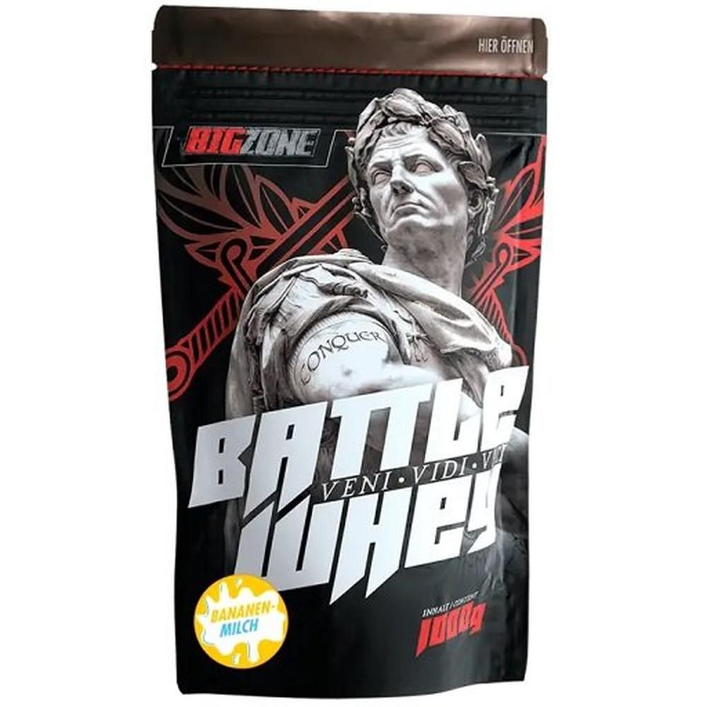 Schwarze Beutel mit "Big Zone" und "Battle Whey" Schriftzug. Bild einer Statue. "Bananen-Milch"-Logo.