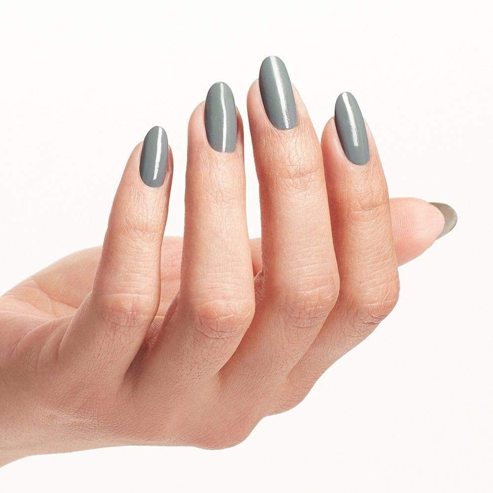 Hand mit lackierten Nägeln. Graue Farbe. Oval geformt.