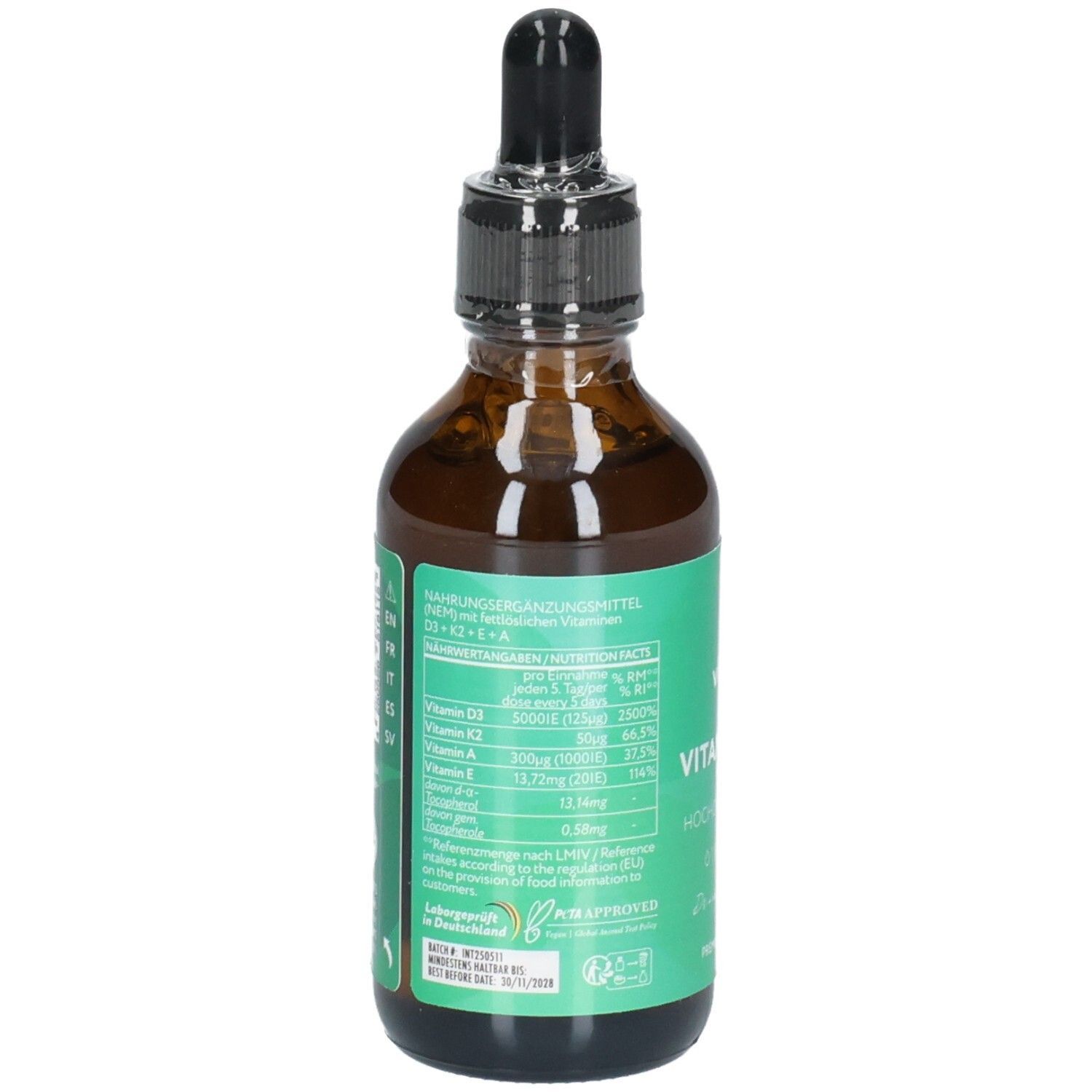 Braune Glasflasche mit Pipettenverschluss, gefüllt mit Flüssigkeit. Grüne Etiketten mit Nährwertangaben und Vitaminen.