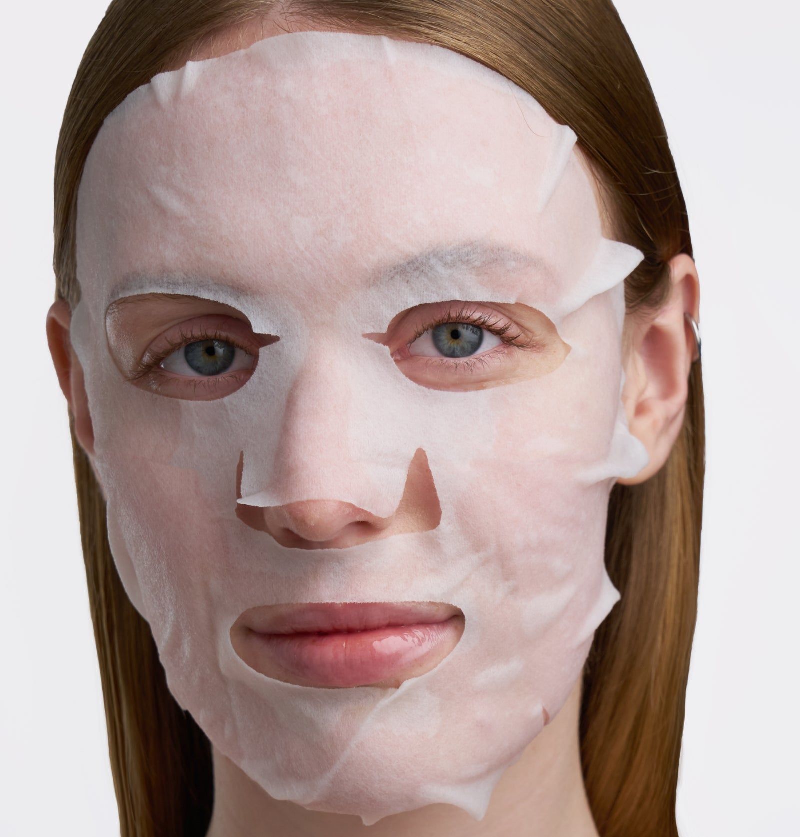 Gesicht einer Person mit einer weißen Gesichtsmaske. Die Maske bedeckt Augen, Nase und Mund.