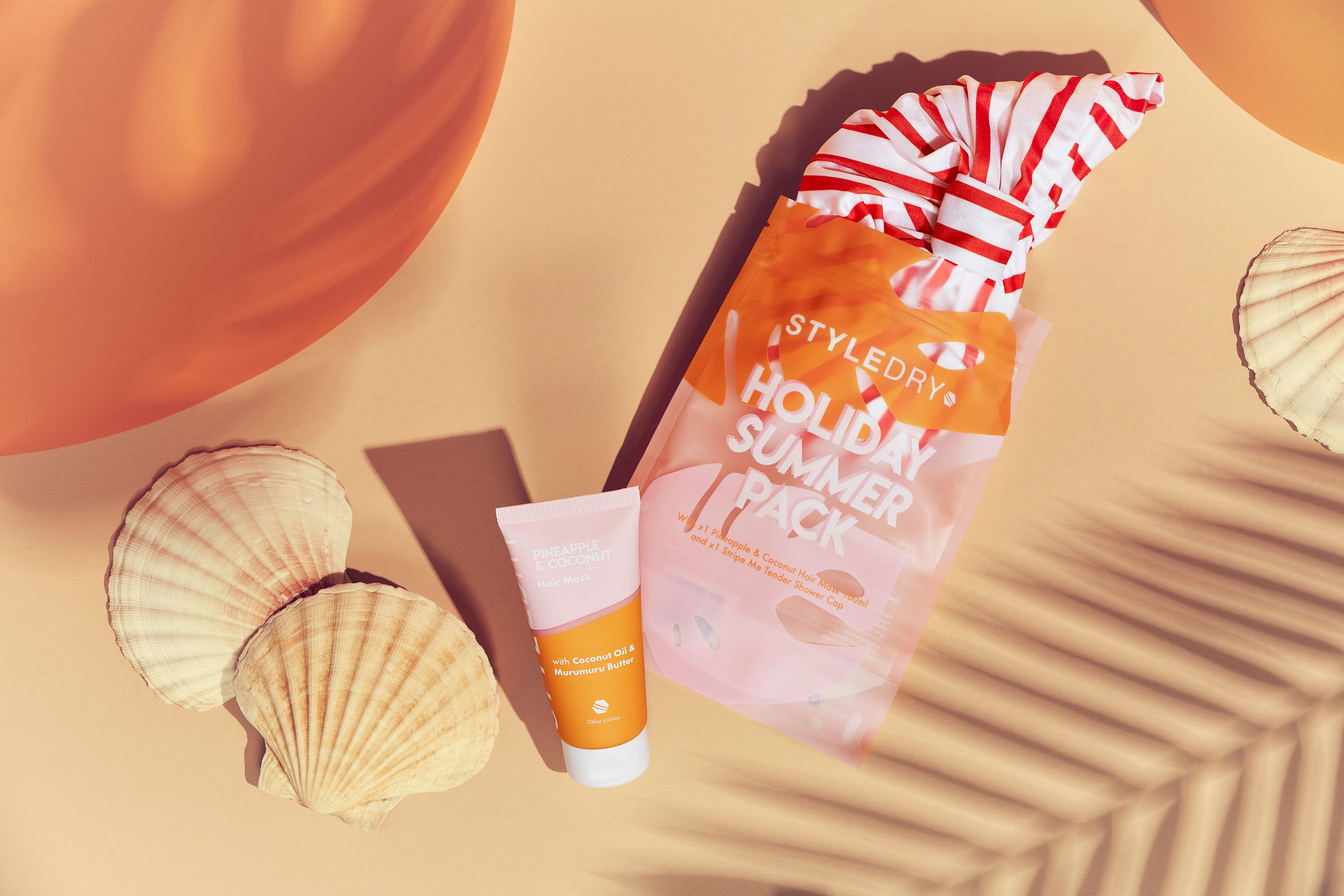 Ein STYLEDRY Holiday Summer Pack. Enthält eine Tube, eine Tasche mit Textilien und Muscheln. Aufschrift: Holiday Summer Pack.