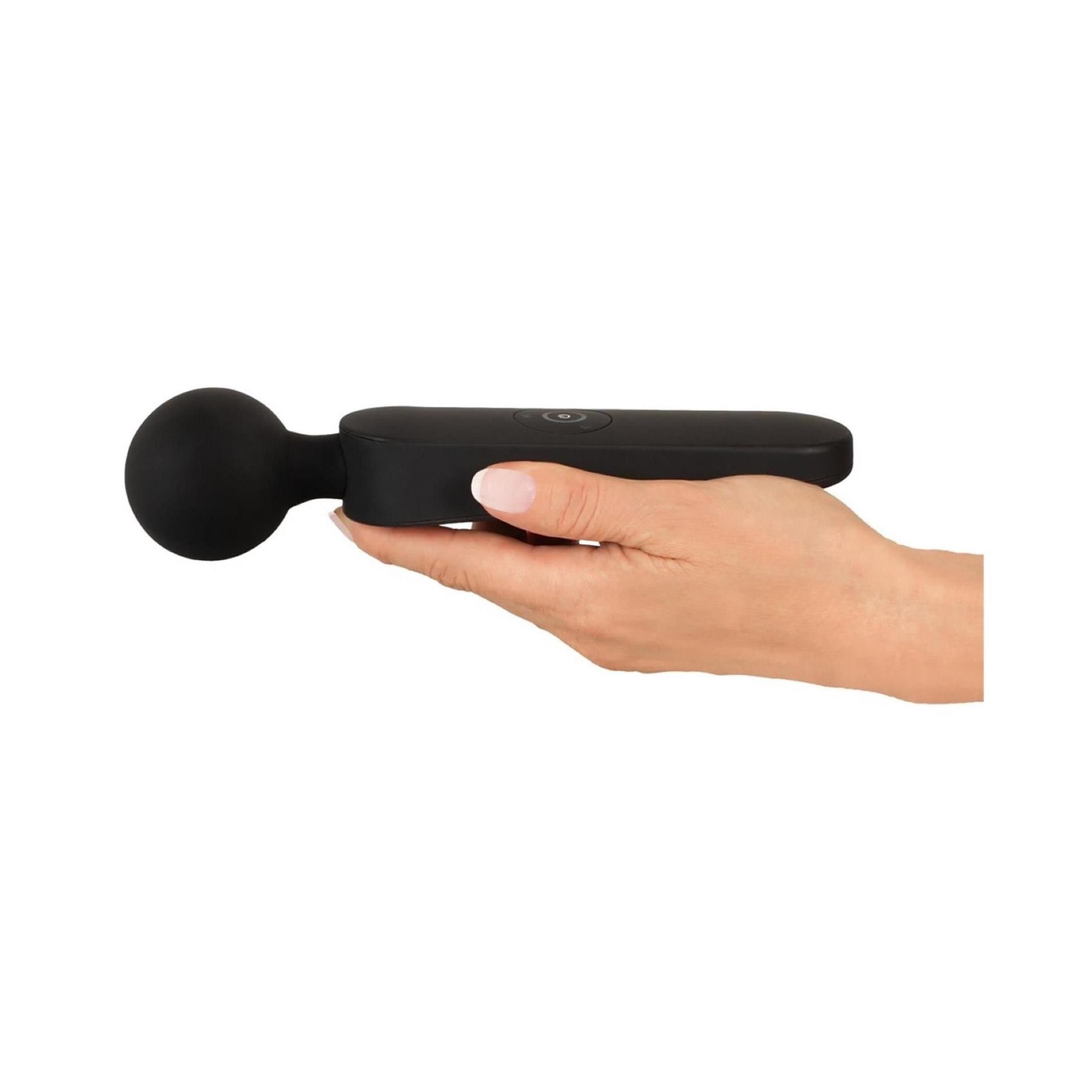 Schwarzer Vibrator in einer Hand gehalten. Der Vibrator hat einen Bedienknopf.