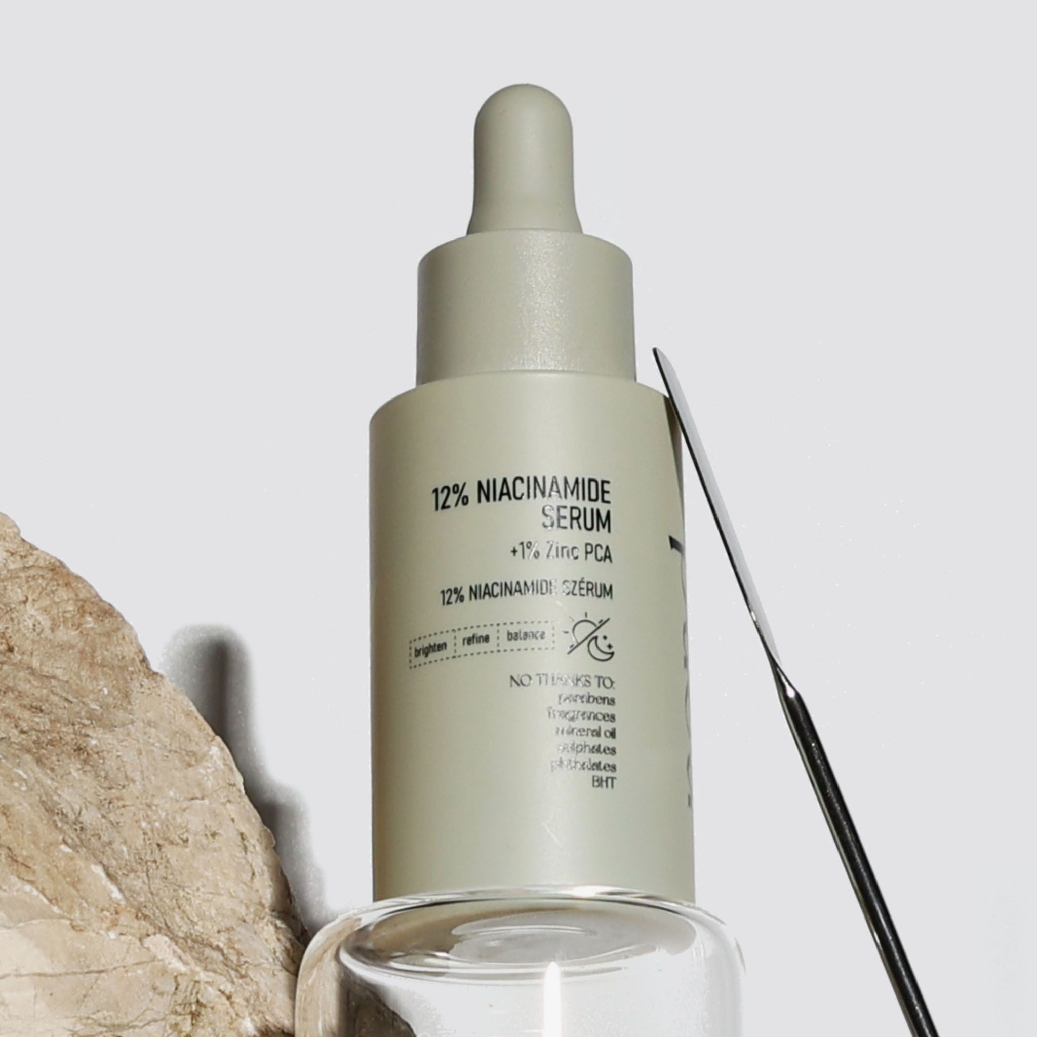 Beige Flasche mit Pipettenaufsatz, 12% Niacinamid Serum, nahaufnahme.