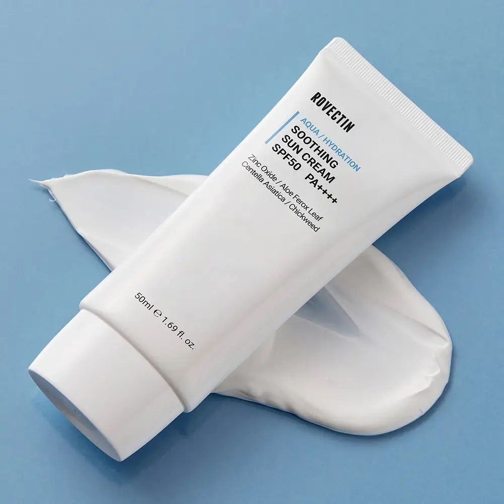 Weiße Tube ROVECTIN Aqua Soothing Sun Cream SPF50+ PA++++ auf blauem Untergrund. Produktname und Inhaltsstoffe sind aufgedruckt. Creme daneben.