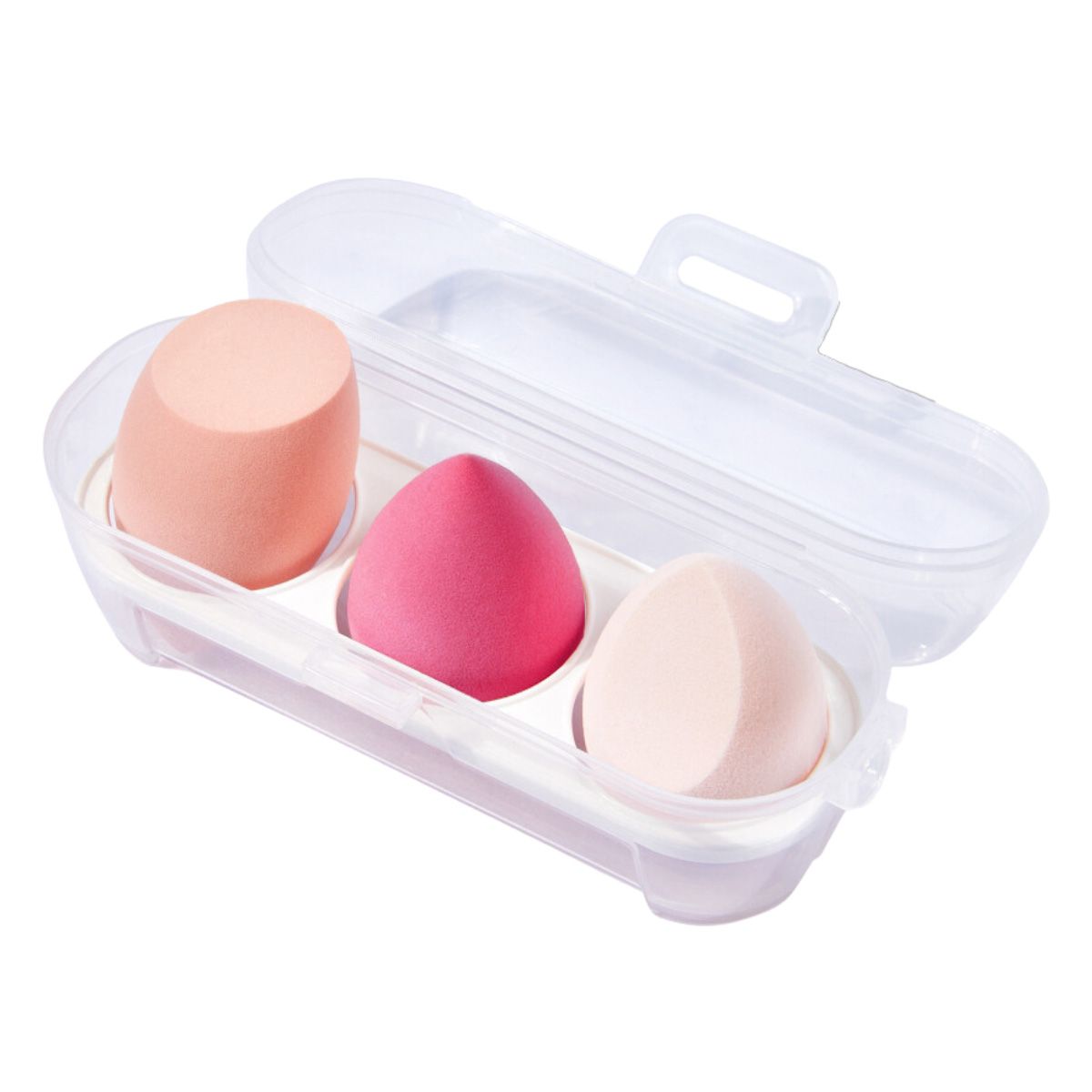 Drei Make-up-Schwämme in einer transparenten Kunststoffbox. Verschiedene Farben: Pfirsich, Pink und Beige. Eiförmig und zylindrisch.