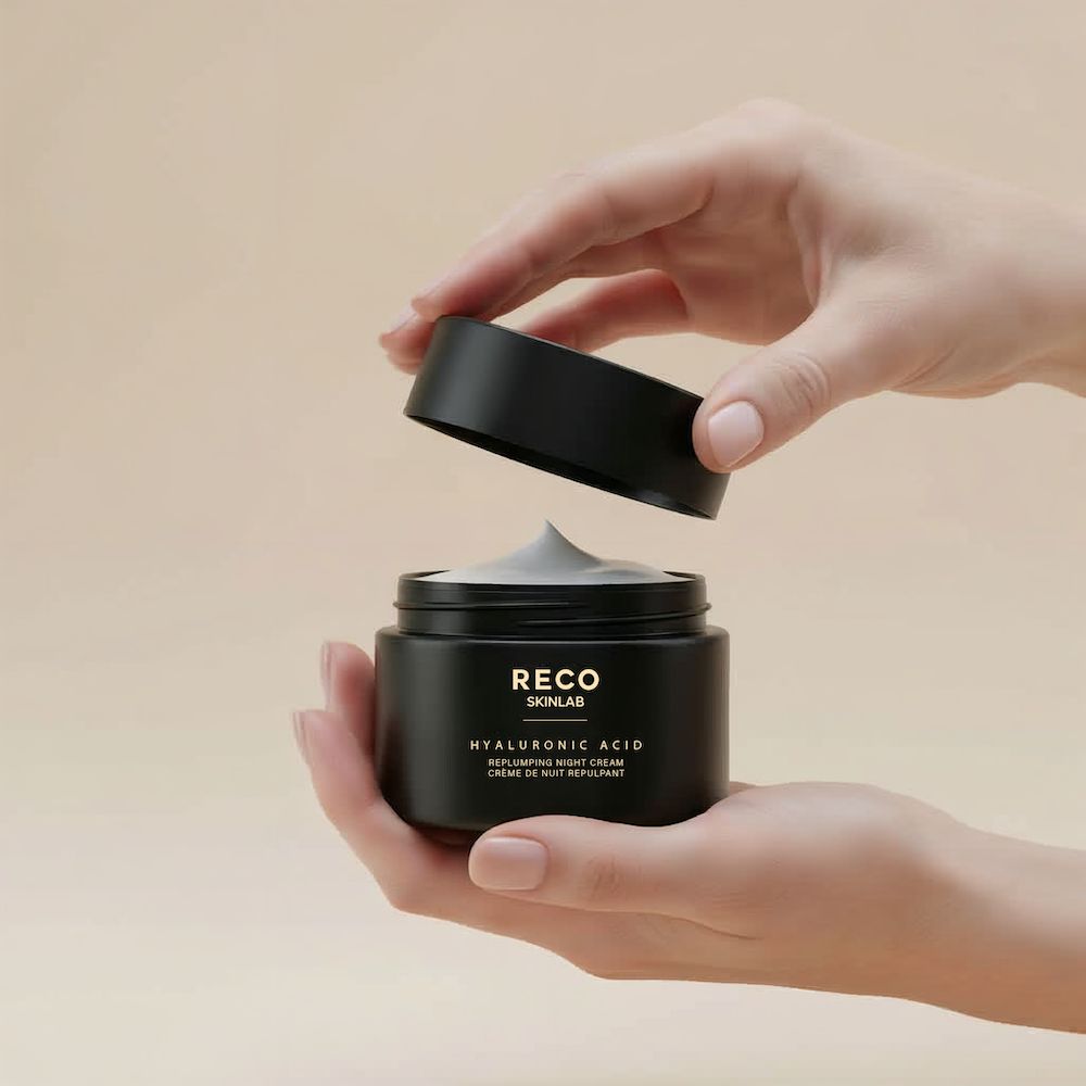 Hände halten einen schwarzen Tiegel von RECO SKINLAB mit offenem Deckel. Beschriftung: Hyaluronic Acid, Replumping Night Cream.
