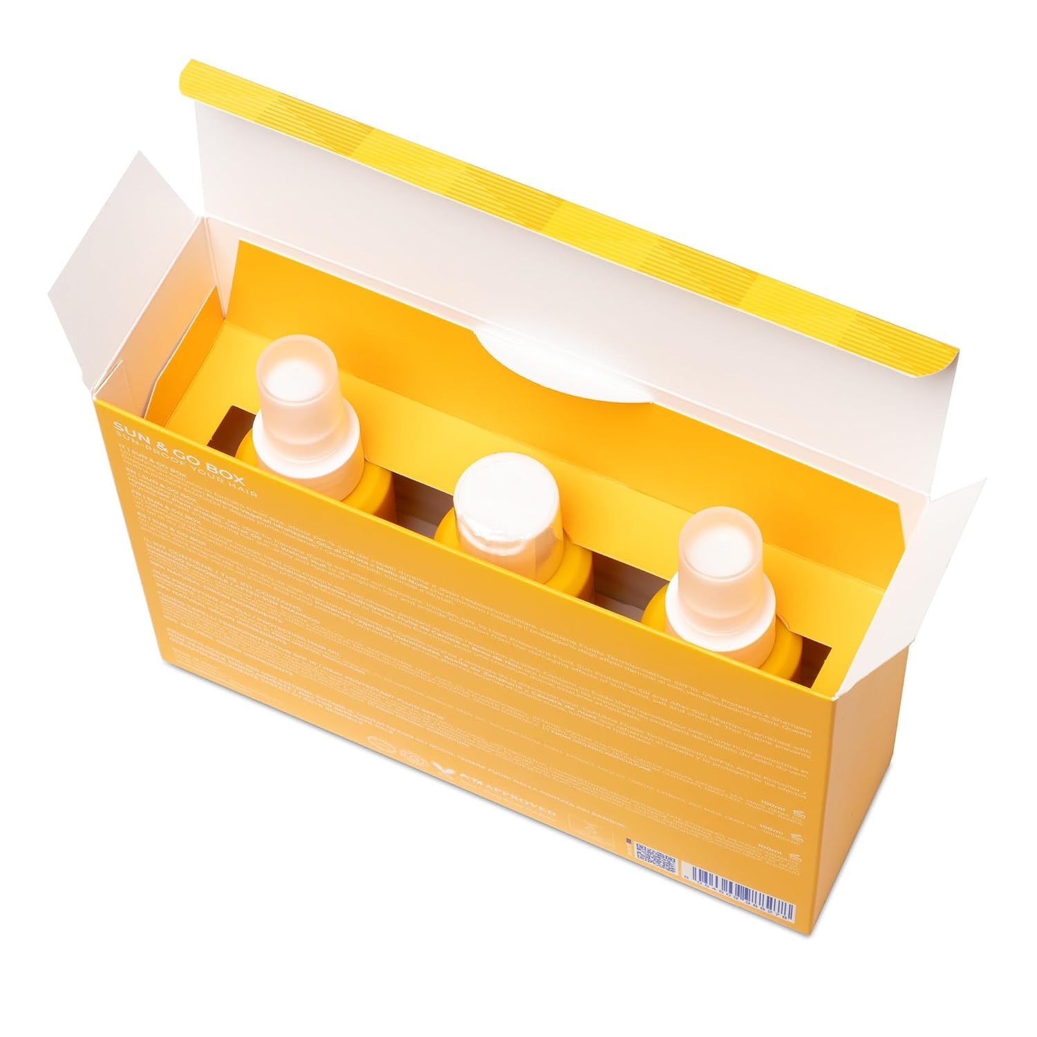 Geöffnete gelbe Box mit drei Flaschen, von oben betrachtet.