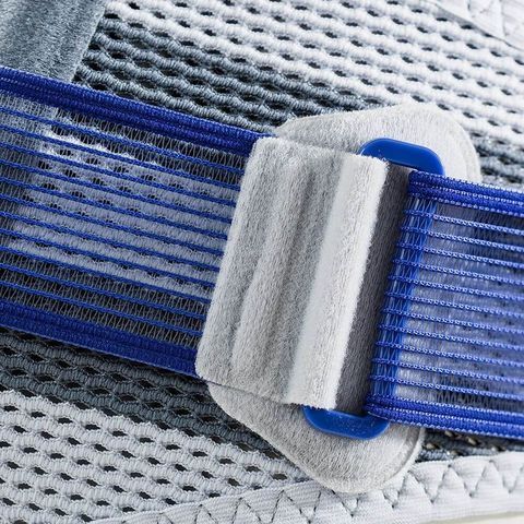 Detailansicht der SacroLoc titan Beckenorthese. Blau-graue Gurte, Klettverschluss und Mesh-Material. Logo sichtbar.