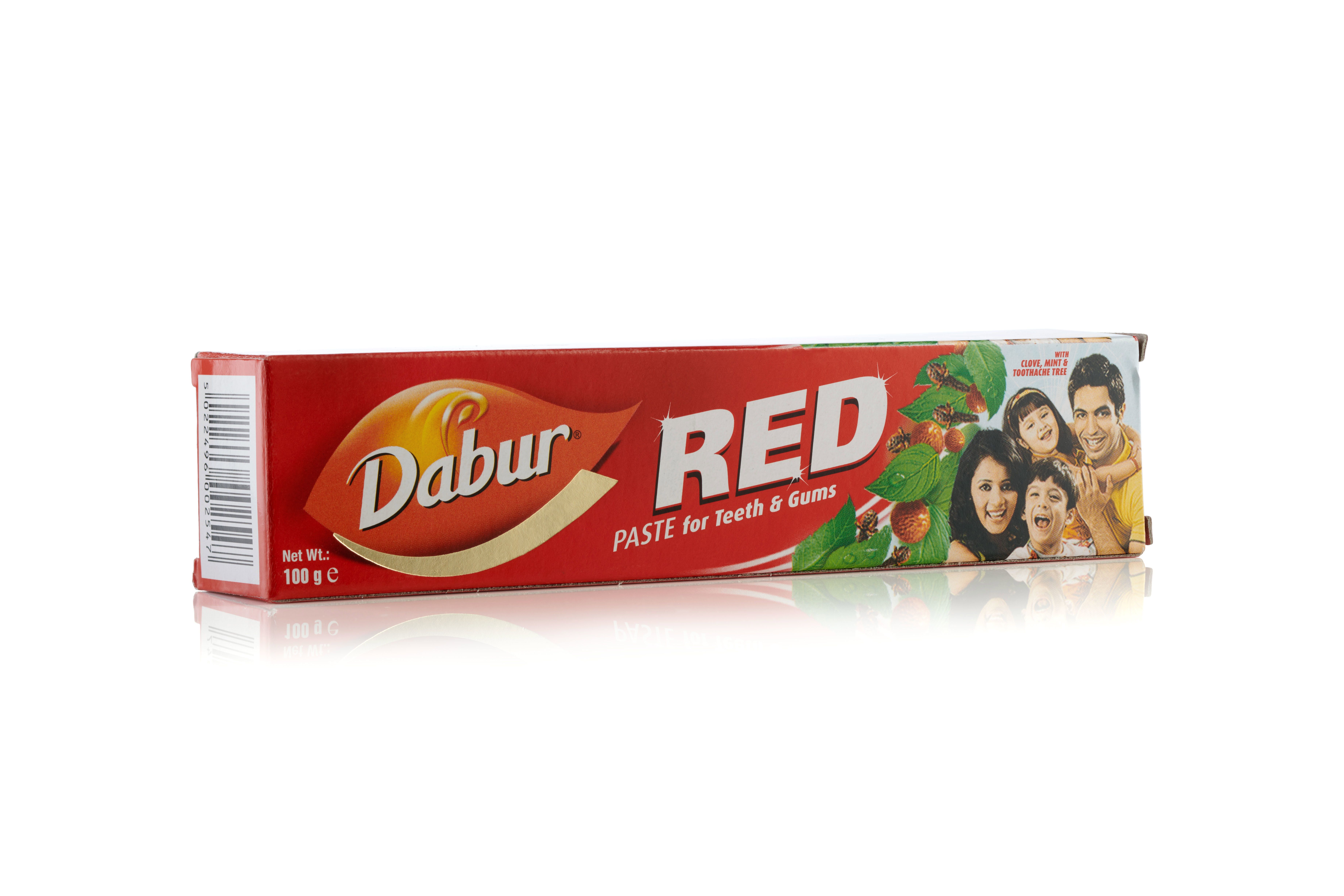 Dabur Red Paste Zahnpasta-Tube und Karton. Rote Verpackung mit weißem und gelbem Schriftzug.