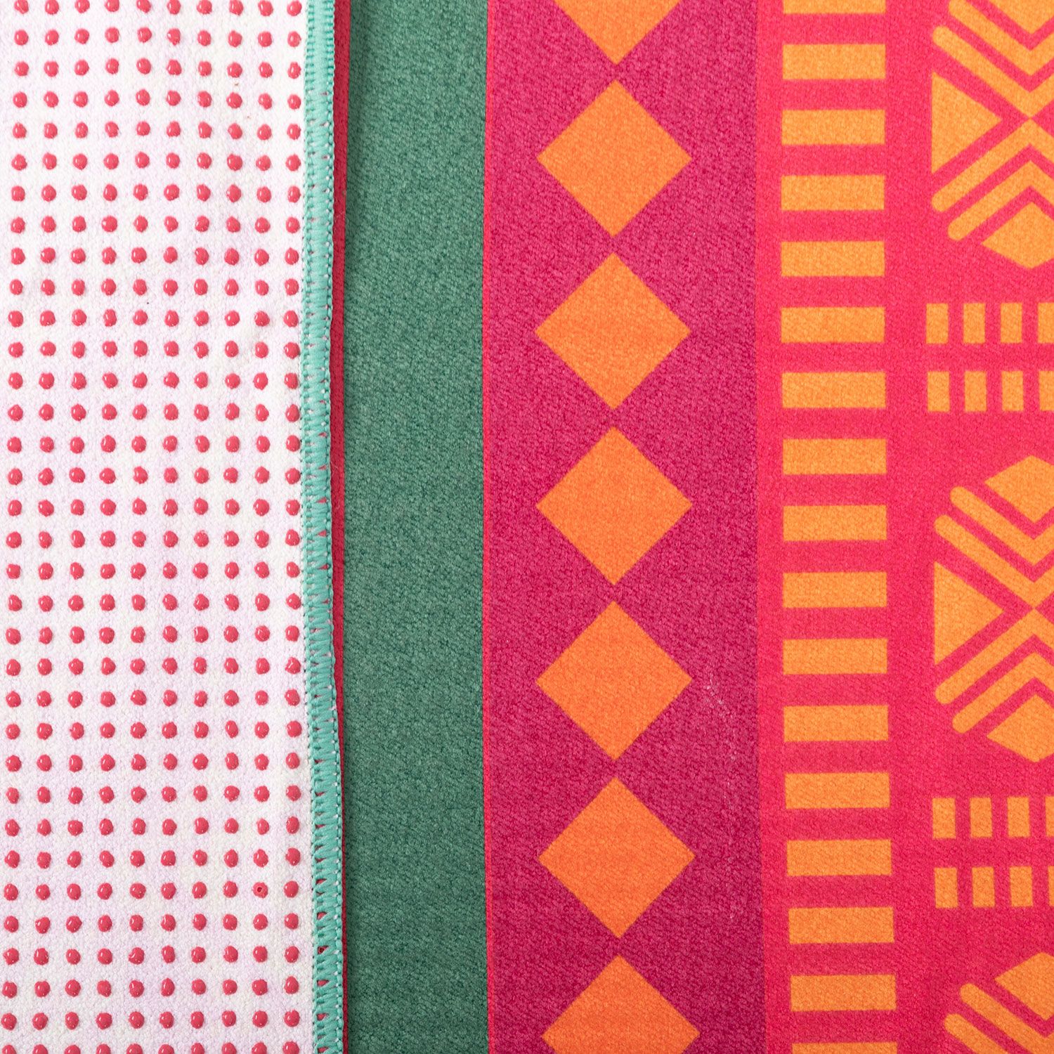 Nahaufnahme von Yoga-Handtuch-Mustern. Rot, gelb, grün und weiß mit Punkten und geometrischen Formen.