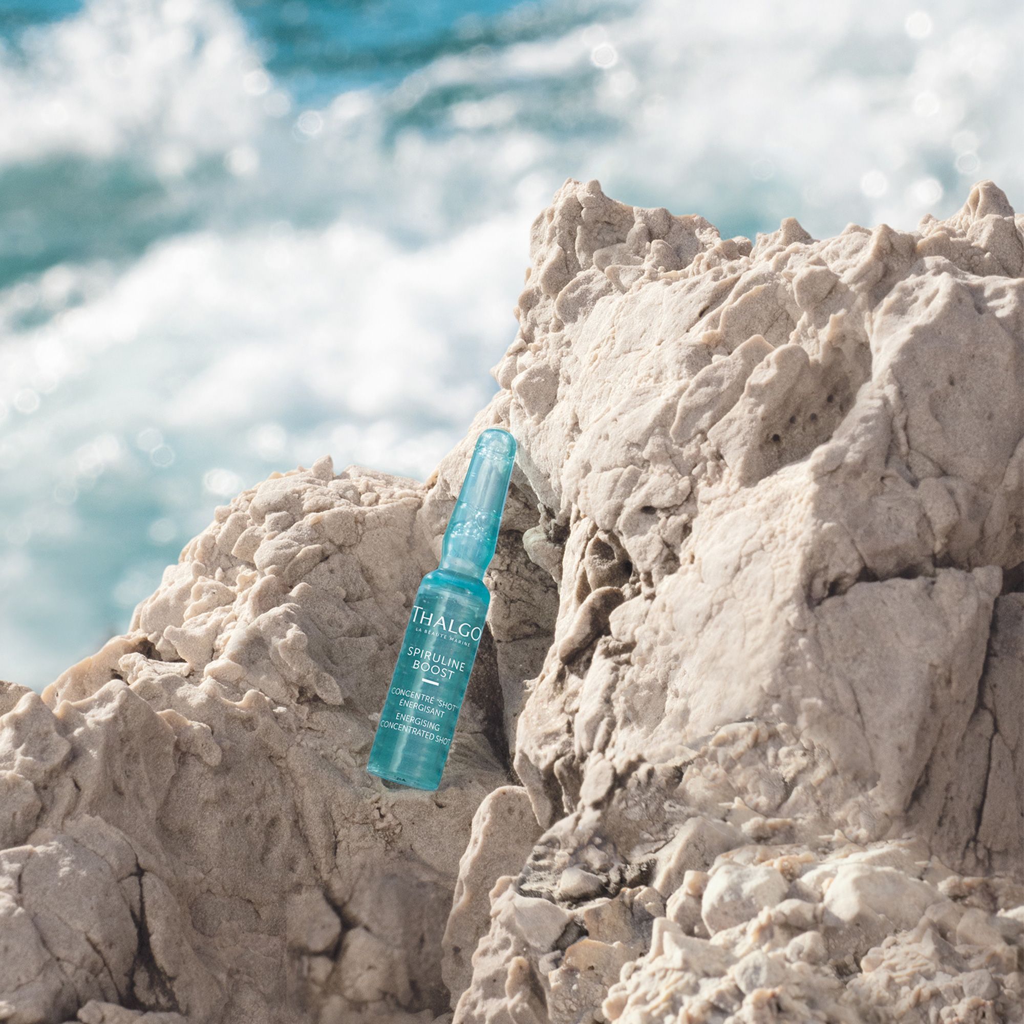 Blaue Ampulle auf Felsen. Beschriftung: THALGO, Spiruline Boost, Concentré Shot Énergisant.