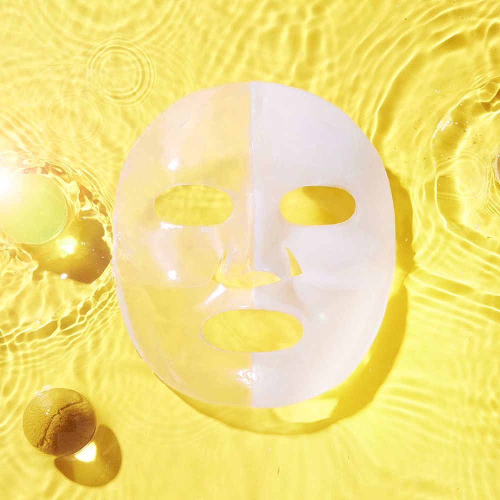 Advanced Snail Mucin Glass Glow Hydrogel Mask auf gelbem Hintergrund mit Wasser-Effekt.