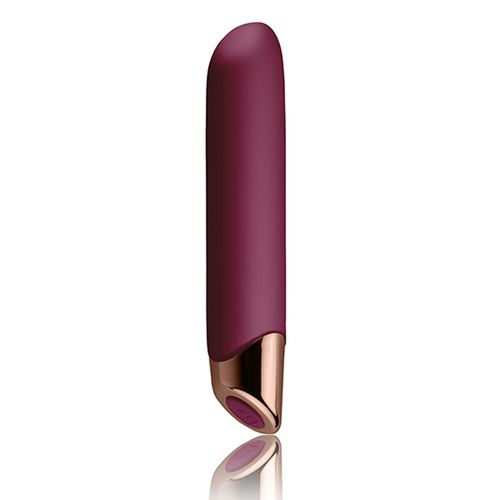Burgunderfarbener Vibrator mit goldfarbenem Akzent am unteren Ende. Glatte Oberfläche. Reflektiert auf einer Oberfläche.