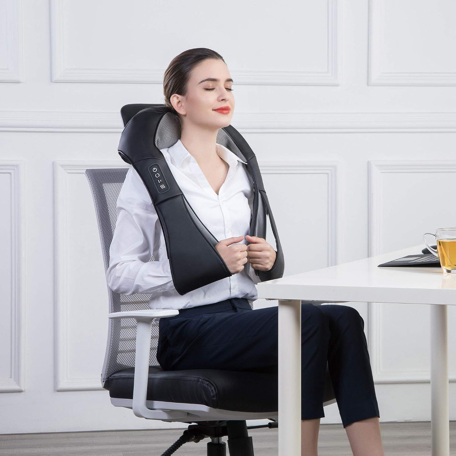 Frau benutzt ein Nackenmassagegerät im Büro.