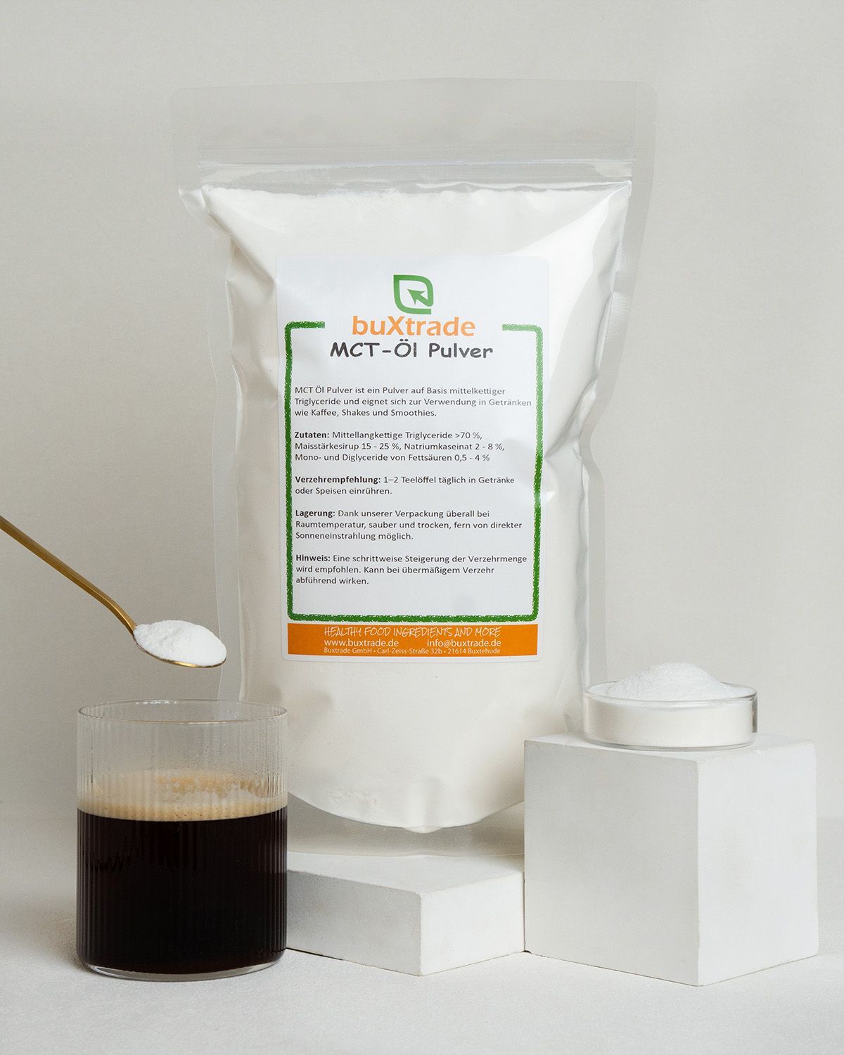 Ein Glas Kaffee, ein Löffel MCT-Öl Pulver und eine Schale Pulver.
