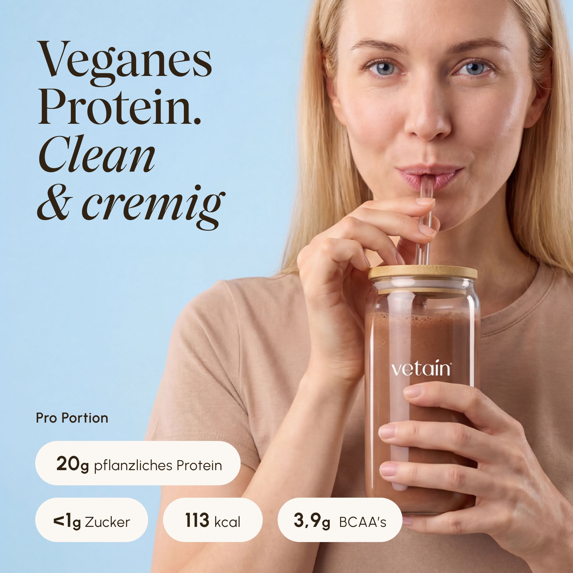 Frau trinkt veganes Proteinshake aus Glasflasche. Nährwertangaben sichtbar.