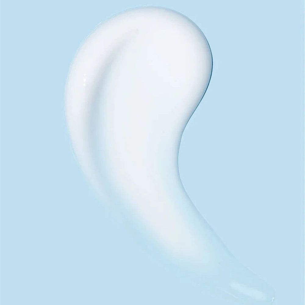 Nahaufnahme einer weißen Creme auf blauem Hintergrund. Die Creme hat eine glatte, glänzende Textur.