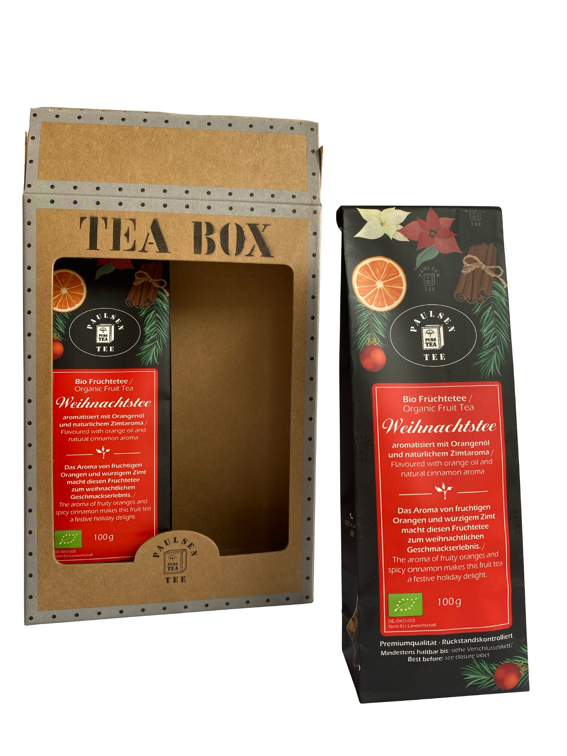 Geöffnete Geschenkbox mit Paulsen Bio Weihnachtsfrüchtetee. Ein Beutel außerhalb der Box. Rote Verpackung mit Text und Logo. Orangen, Zimt, Tannenzweige.
