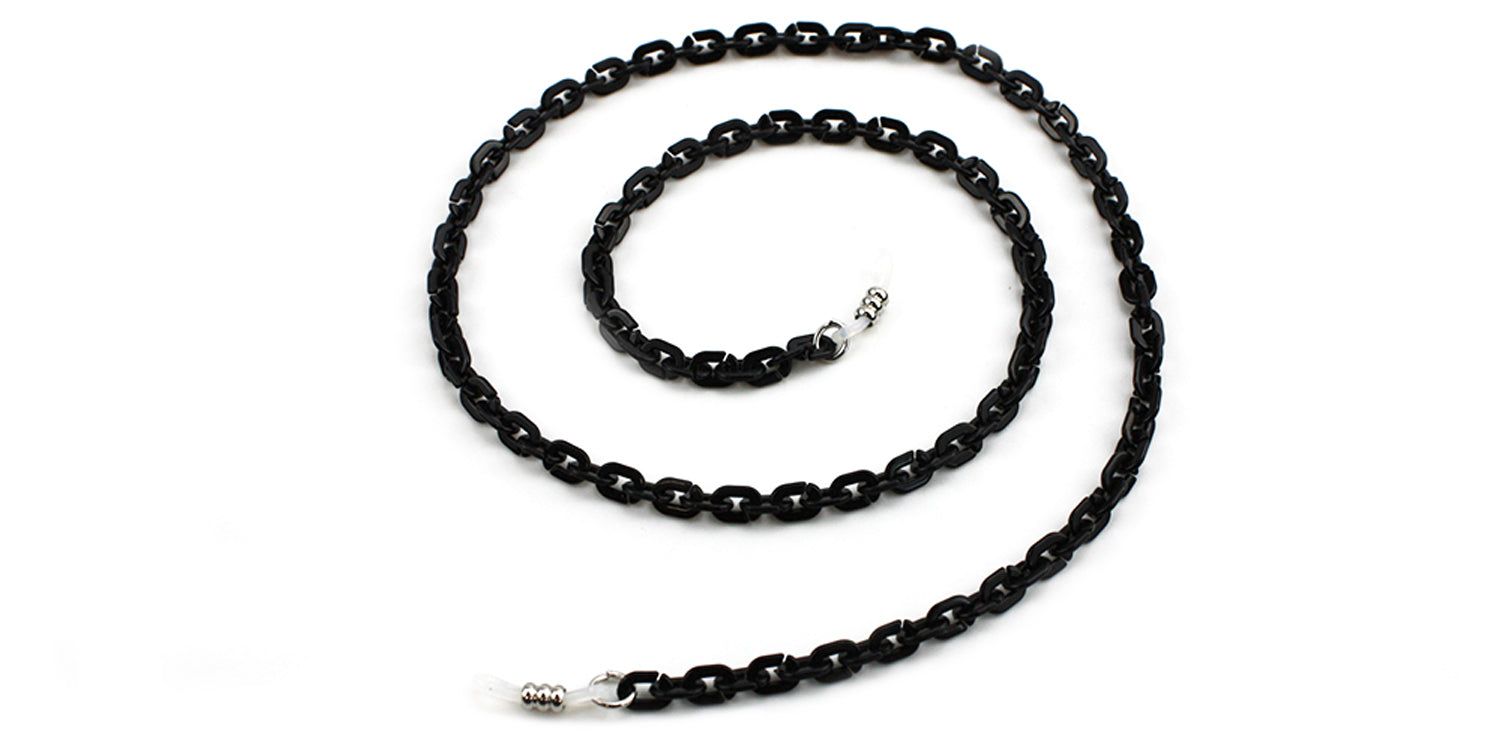 Schwarze Brillenkette mit ovalen Gliedern. Metallverschlüsse an den Enden. Auf weißem Hintergrund.