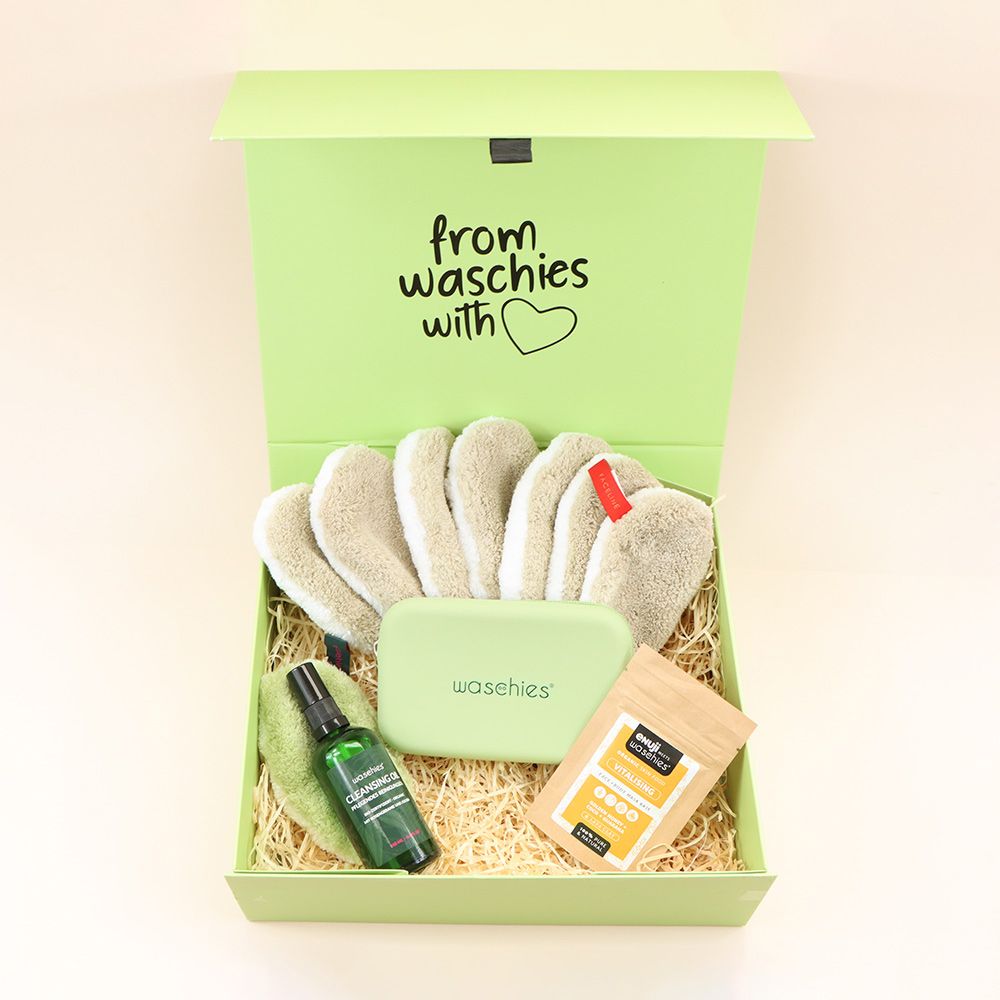Grüne Box mit Produkten. Enthält Waschpads, Reinigungsöl, eine Tasche und ein Päckchen. Aufschrift: from waschies with ❤️.