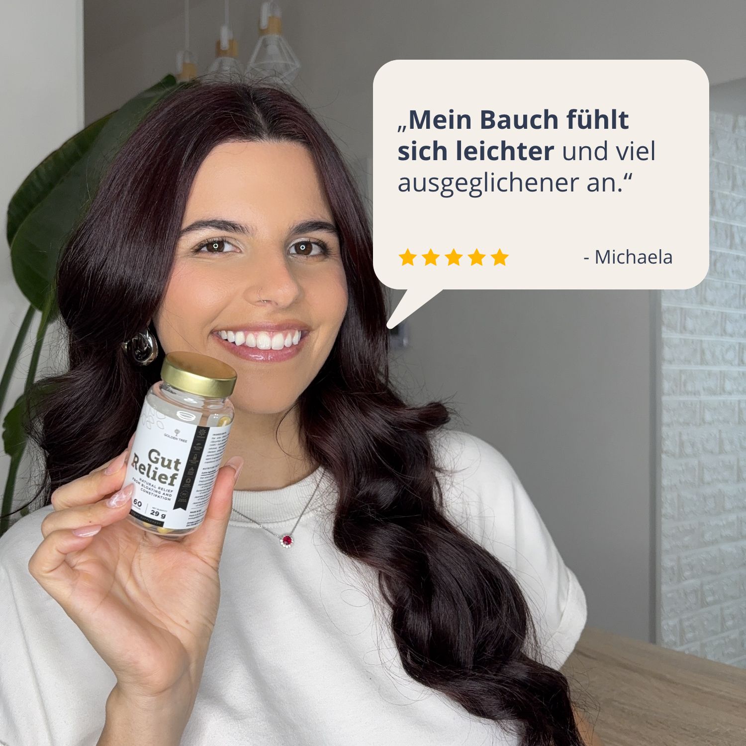 Lächelnde Frau hält eine Flasche Golden Tree Gut Relief und gibt eine positive Bewertung über ihr Bauchgefühl ab.