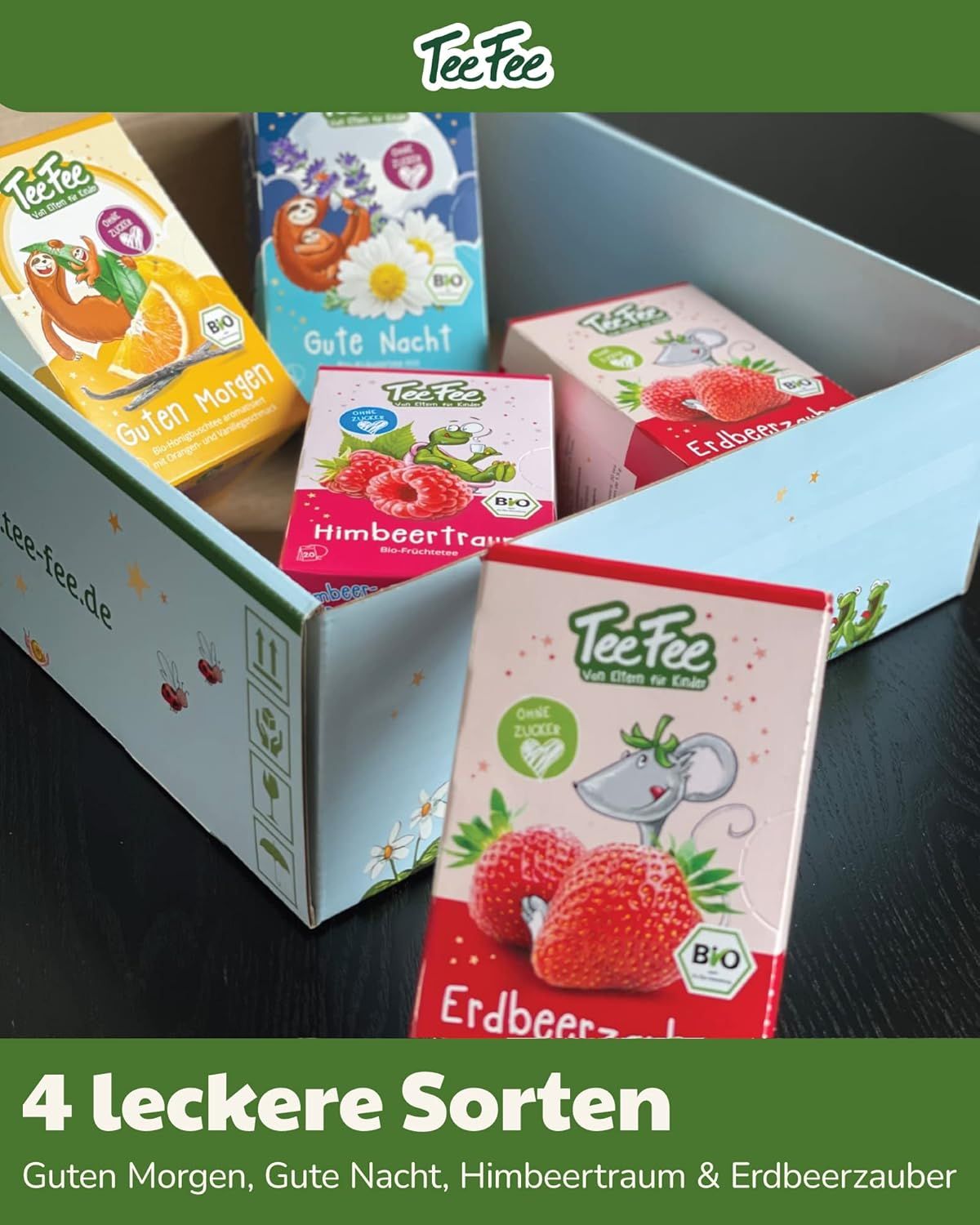 TeeFee Bio-Kindertee-Set in geöffneter Box. 4 Tee-Sorten sichtbar. Aufdrucke: Guten Morgen, Gute Nacht, Himbeer Traum, Erdbeerzauber. Bio-Siegel.