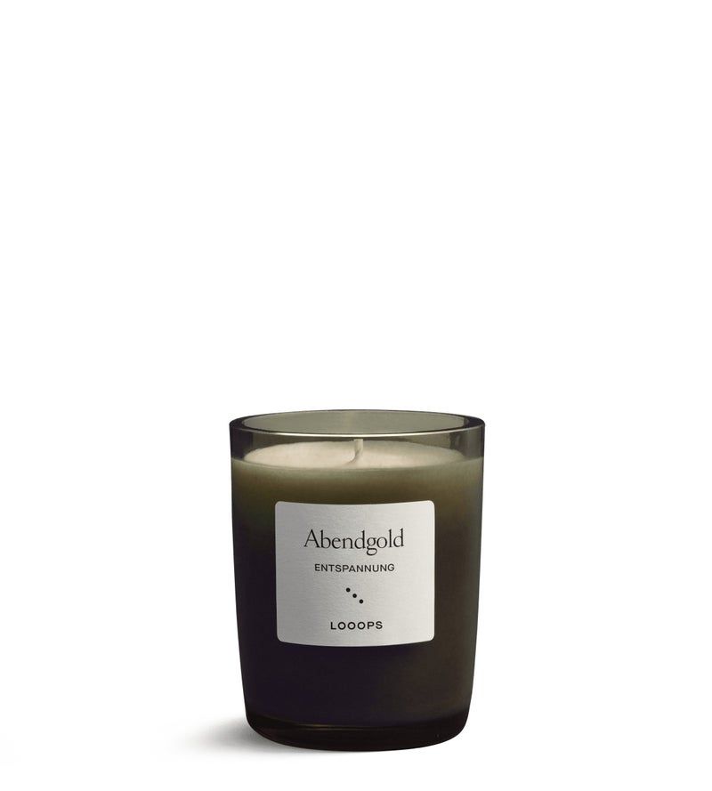 Duftkerze in einem Glas. Auf dem Etikett steht "Abendgold Entspannung" und "Looops".