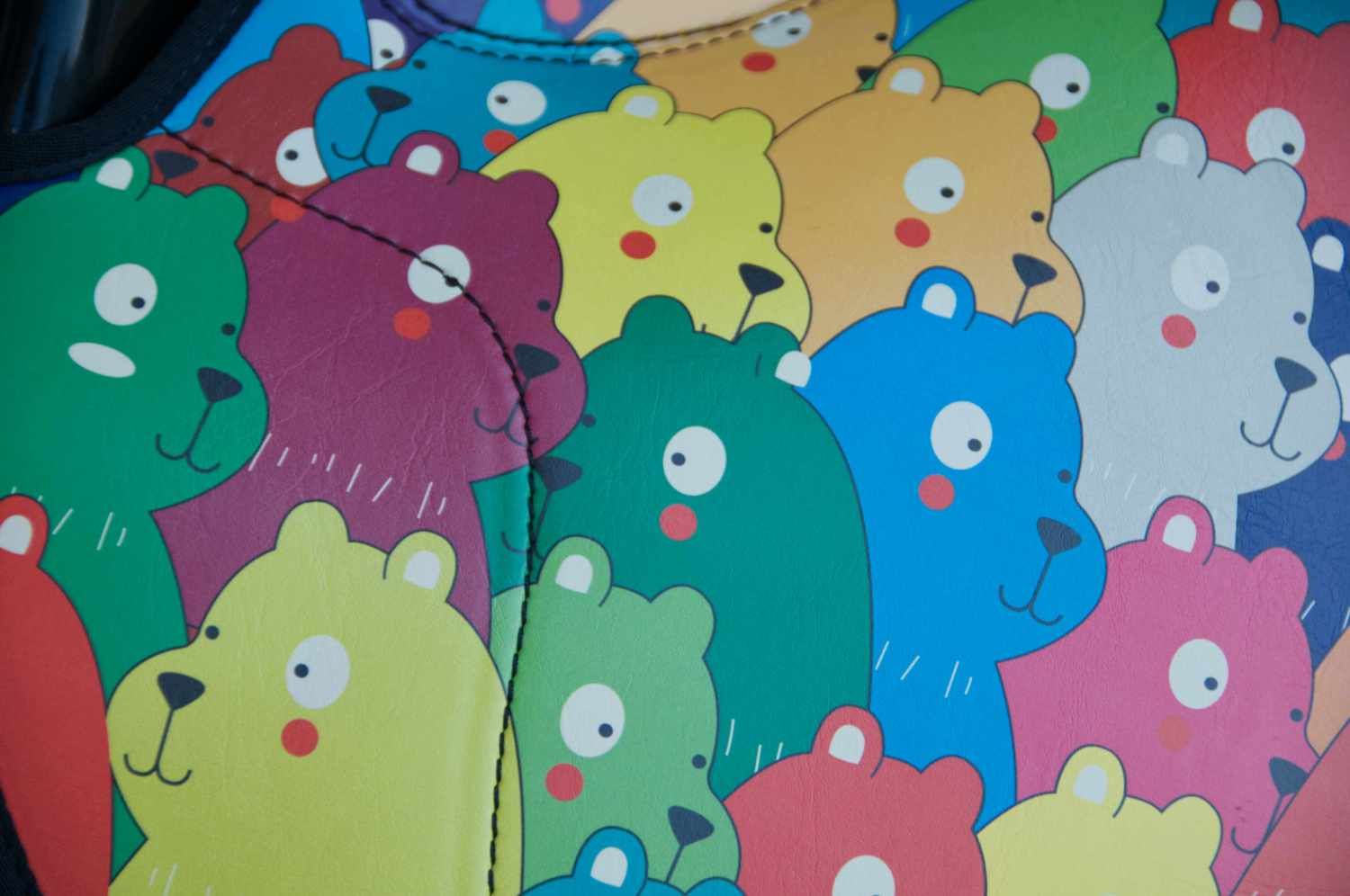 Nahaufnahme des Reitkissen-Musters. Bunte Bärenköpfe in verschiedenen Farben. Detailansicht der Oberfläche.