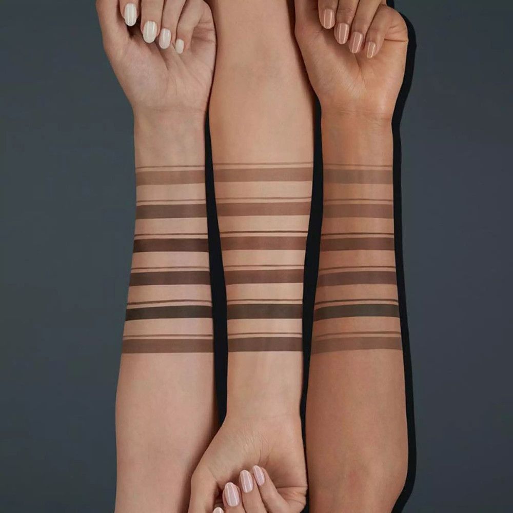 Arme mit verschiedenen Farbtönen von Augenbrauenstiften. Verschiedene Hauttöne.