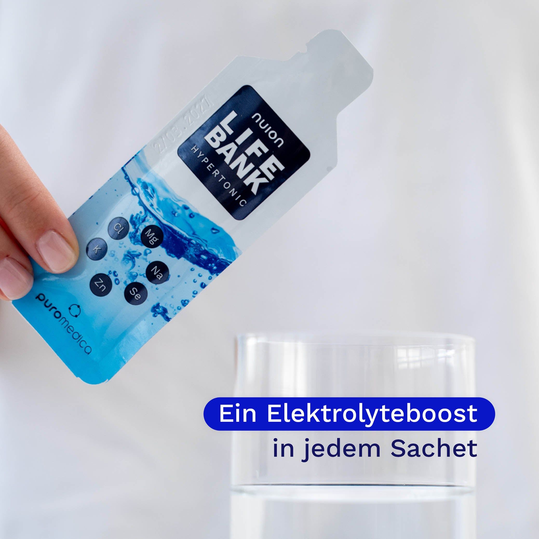 Hand hält Beutel Nuion Life Bank Hypertonic über ein Glas Wasser.