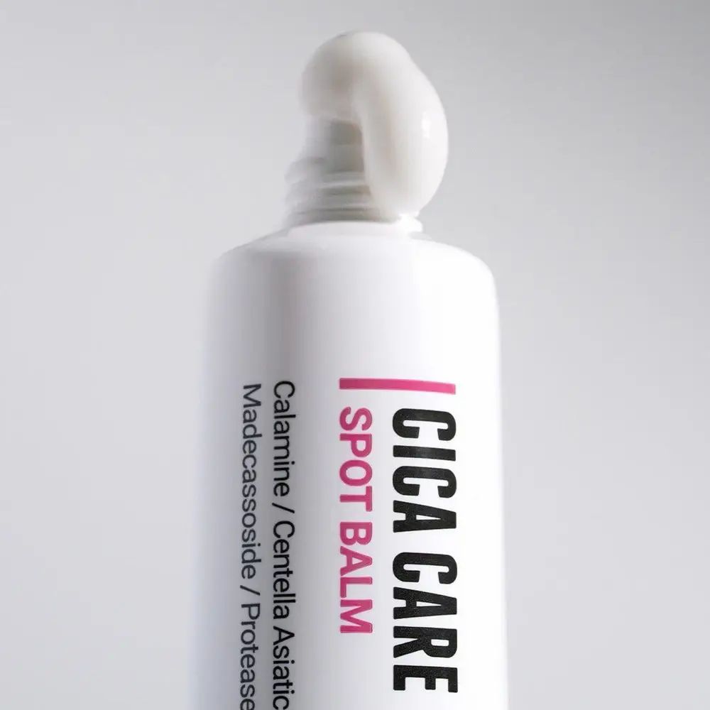 Weiße Tube mit Produkt. Aufschrift: Cica Care Spot Balm. Produkt aus der Tube gedrückt.