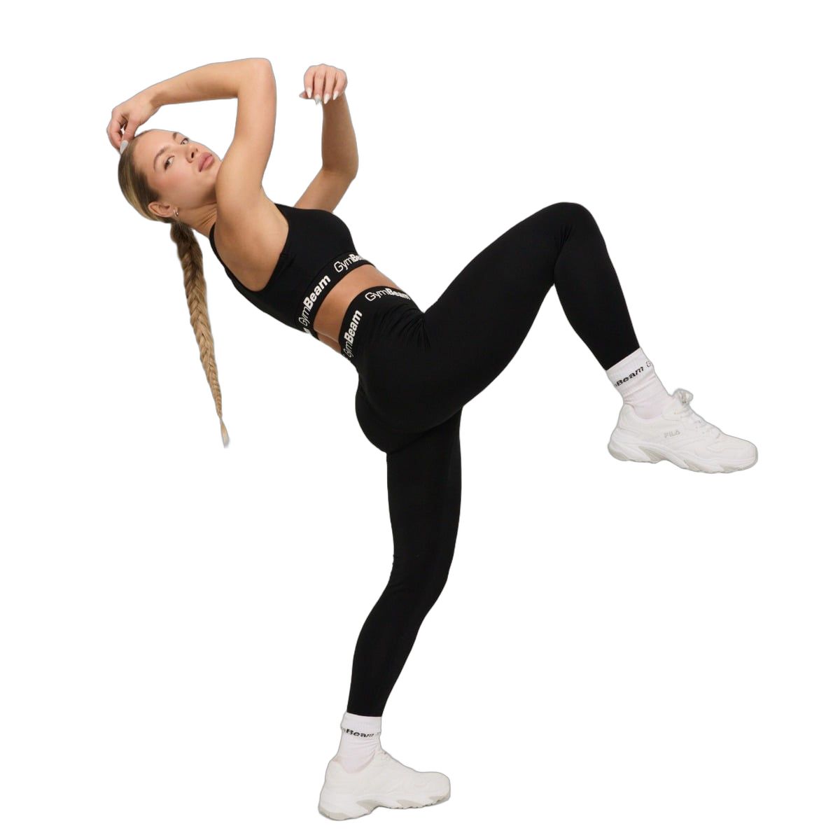 Frau in dynamischer Pose mit schwarzen Leggings und Sport-BH.