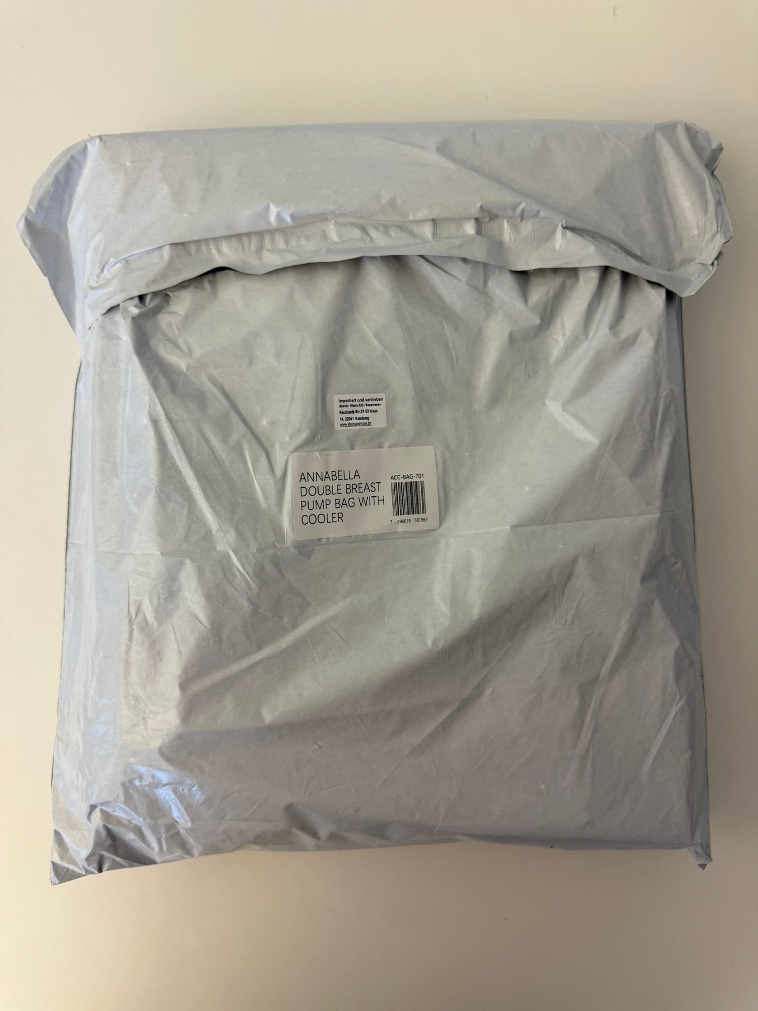 Verpackte Isoliertasche in Plastikfolie. Etikett mit Produktinformationen: 'Annabella Double Breast Pumping Bag'.