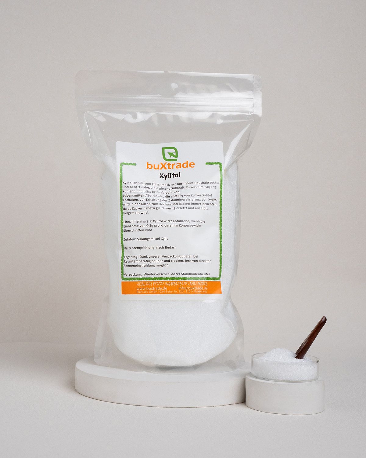 Transparente Verpackung mit Xylit. Etikett mit Produktinformationen und Marke buXtrade Xylitol. Kleiner Behälter mit Xylit.