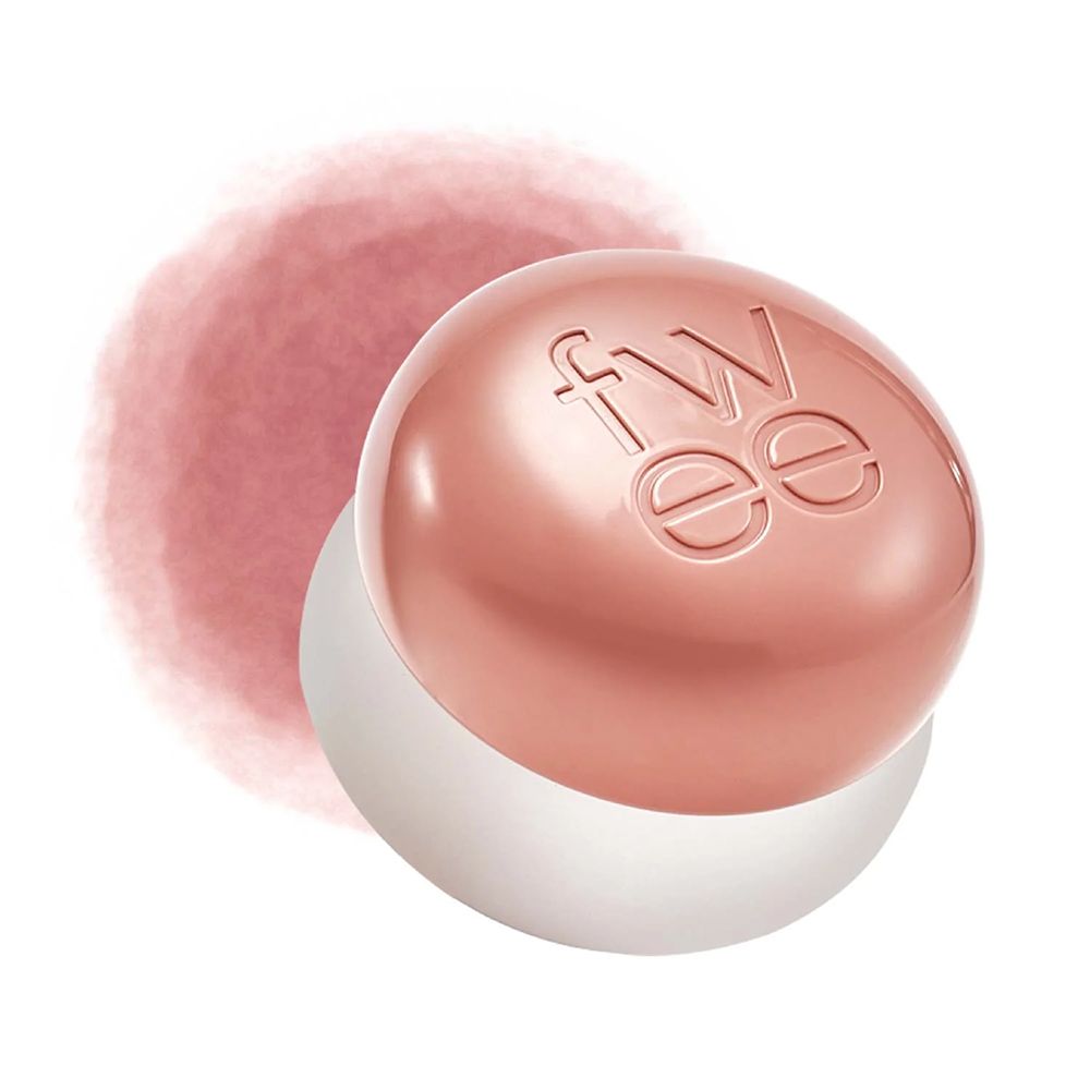Runder, rosafarbener Tiegel mit eingeprägtem Logo und einem Hauch von Rouge daneben.