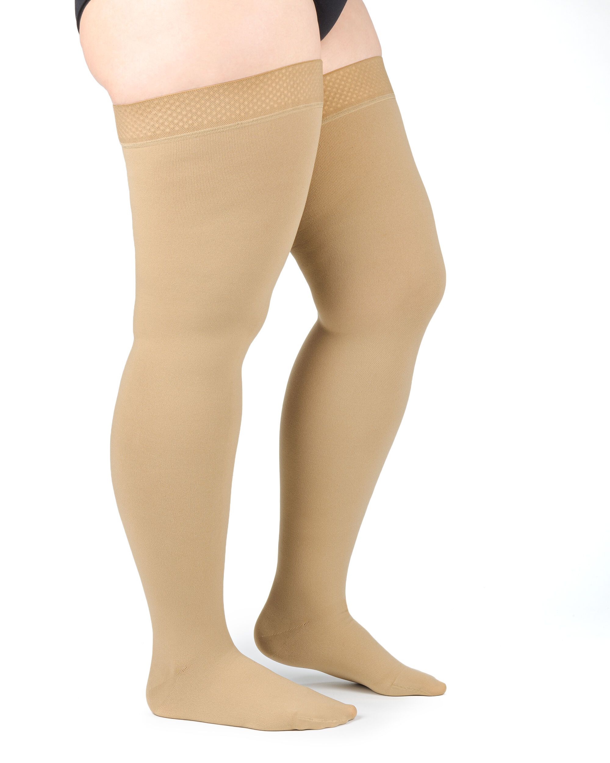 Beige Kompressionsstrümpfe, kniehoch, mit breitem Abschlussband. Baumwollmaterial. Auf hellem Hintergrund.