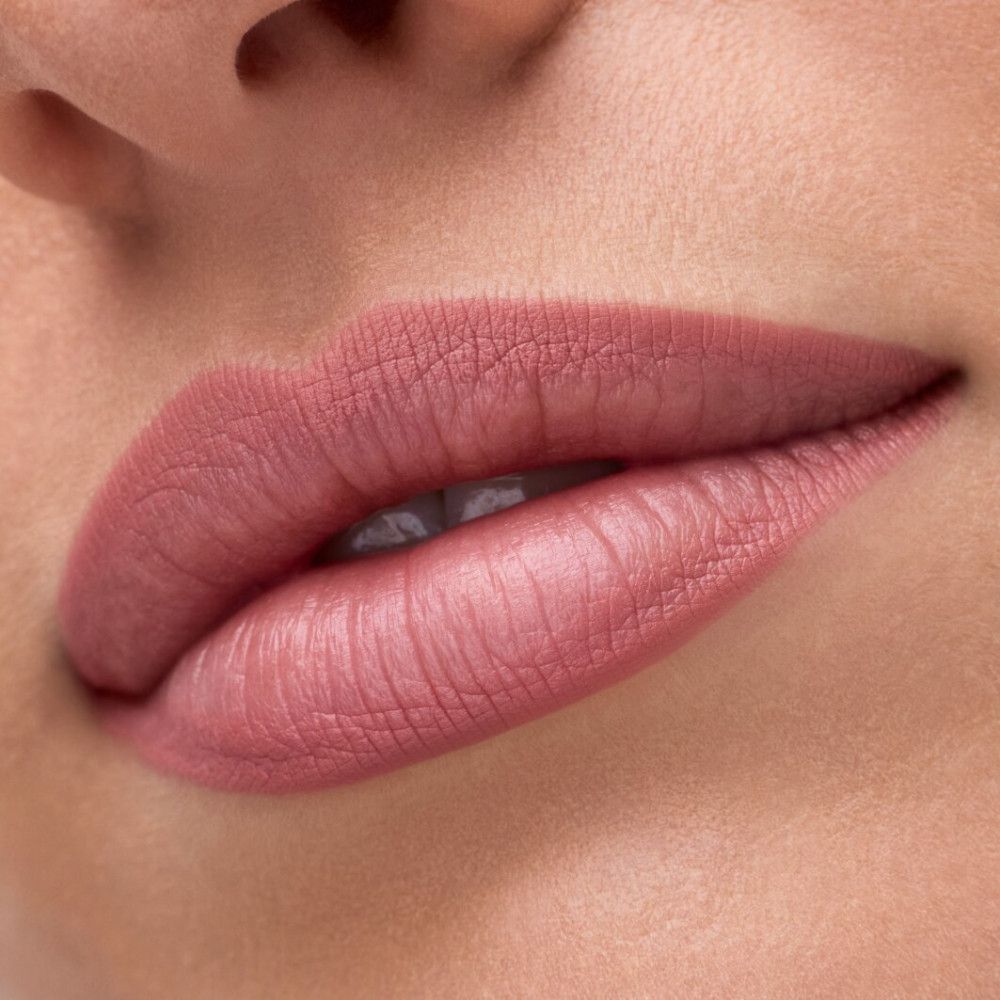 Nahaufnahme von Lippen mit rosafarbenem Lippenstift. Glatte Textur, natürlicher Look.