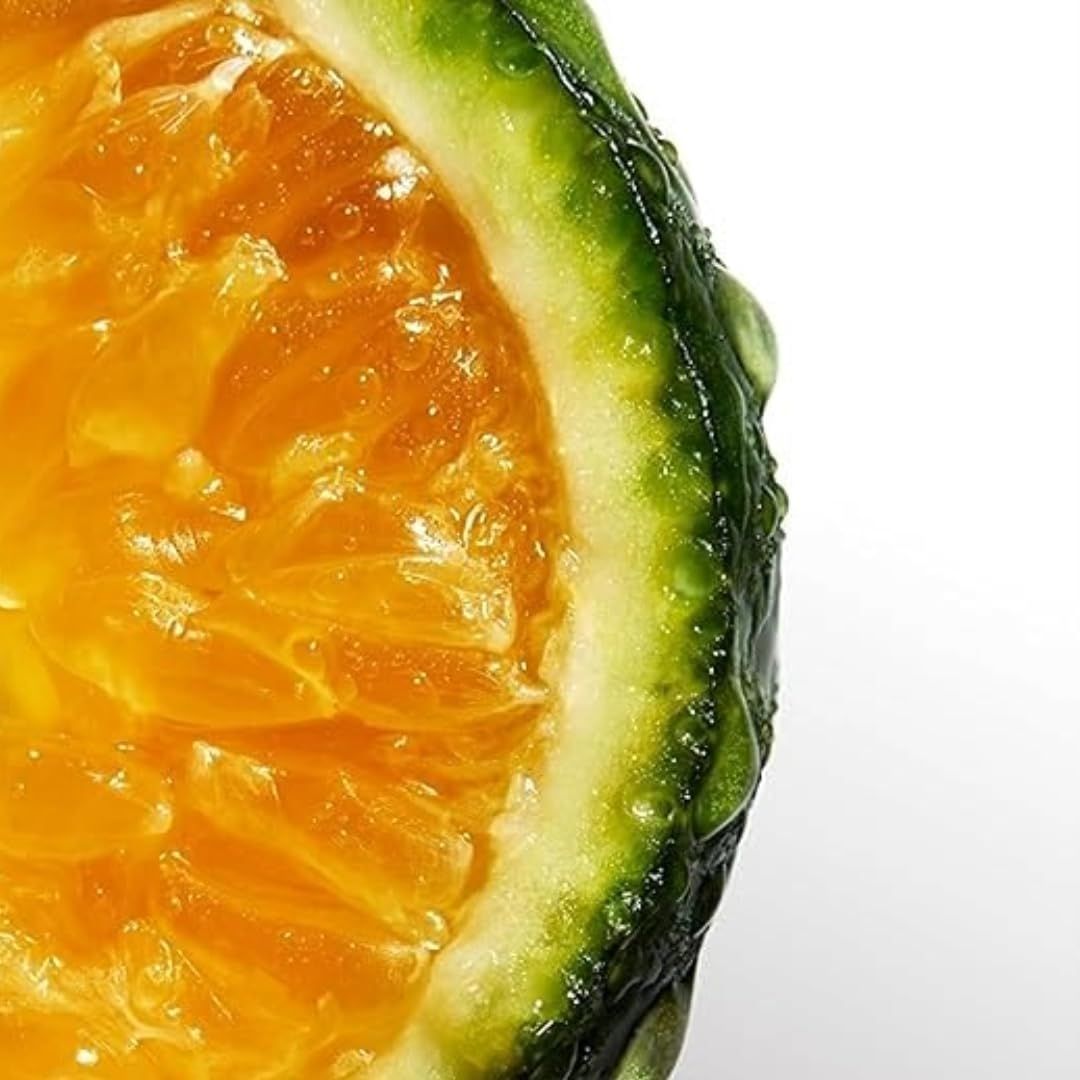 Nahaufnahme einer Orange, aufgeschnitten. Fruchtfleisch orange, Schale grün. Wassertropfen auf der Schale.