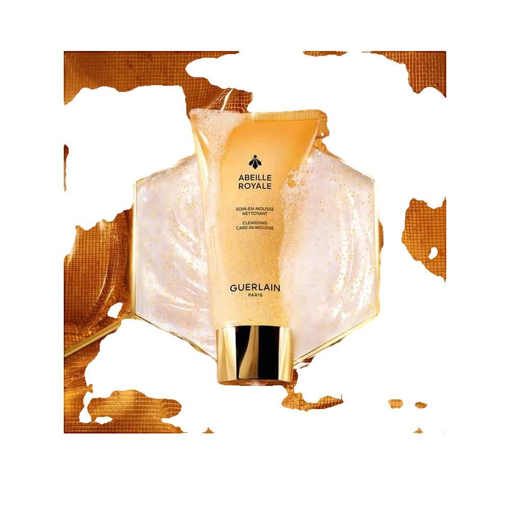 Gelbe Tube mit goldener Kappe. Auf Schaum und goldenem Hintergrund.