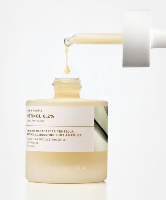 Ampulle mit Pipette, ein Tropfen Serum fällt heraus. Hautpflegeprodukt.