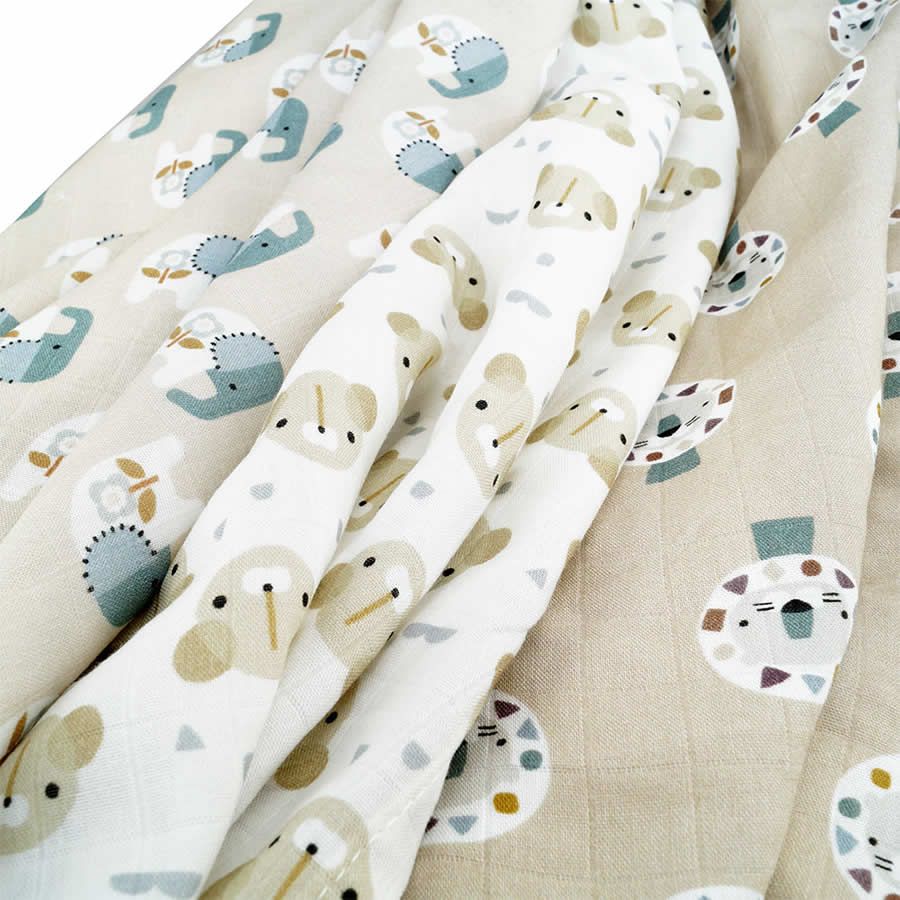 Mehrere Mullwindeln mit Tierdruckmuster. Beige, weiß und blau. Stoffe gefaltet und überlappend.