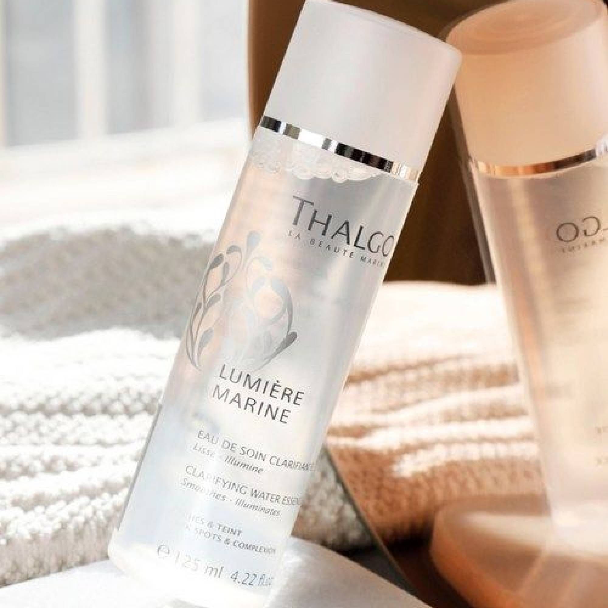 Schräg stehende Flasche mit Produkttext. "Thalgo"-Logo, "Lumière Marine" und weitere Produktinformationen.