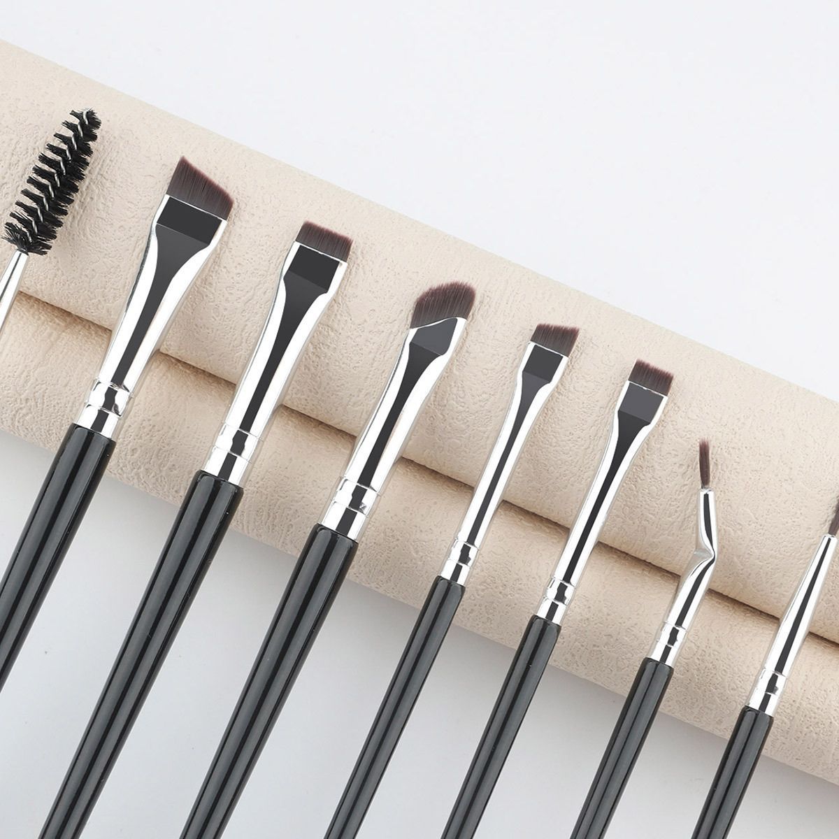 Set mit acht Make-up-Pinsel mit schwarzen Griffen und silbernen Zwingen. Enthält einen Bürstenkopf und verschiedene abgewinkelte und gerade Pinsel.