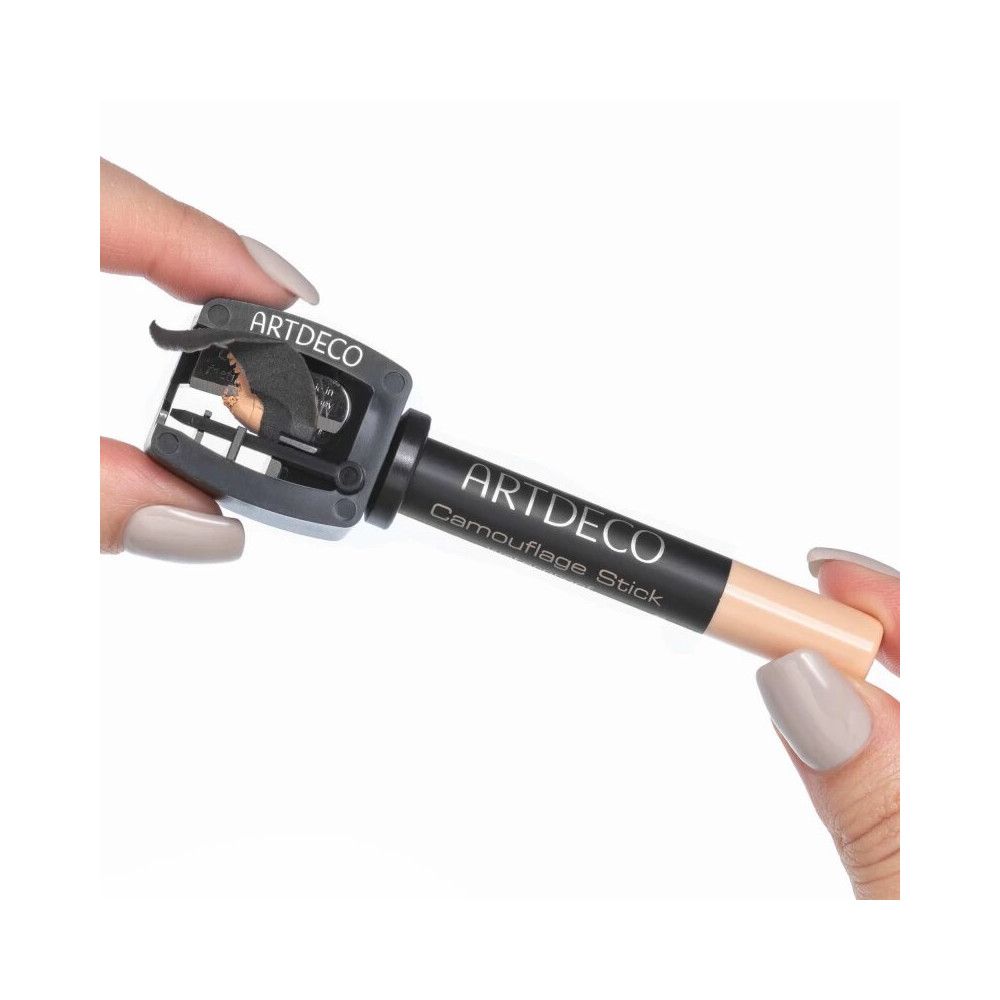 Hände halten einen Spitzer und einen Camouflage Stick. Spitzer mit ARTDECO-Logo. Stick mit ARTDECO Camouflage Stick-Aufdruck.