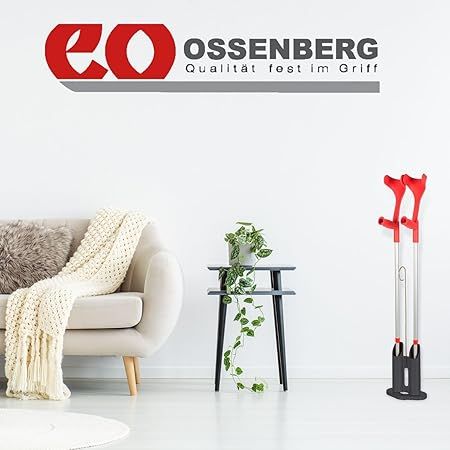 Wohnzimmer mit Gehhilfenständer und Gehhilfen. Ossenberg-Logo oben links.