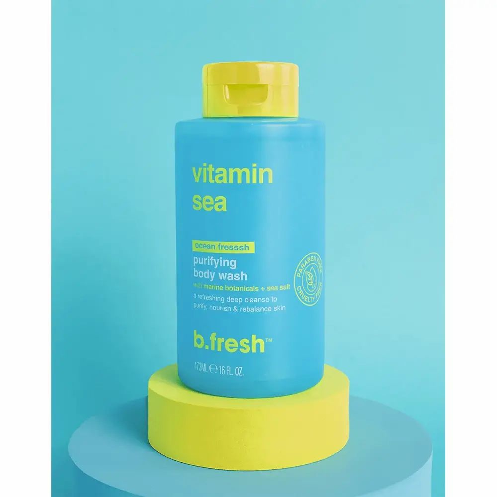 Blaues Duschgel mit gelbem Deckel. Aufschrift "Vitamin Sea" und "b.fresh". Steht auf gelbem Podest.