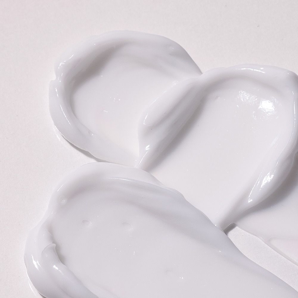 Nahaufnahme von weißen Creme-Schlieren auf weißem Hintergrund. Textur sichtbar.
