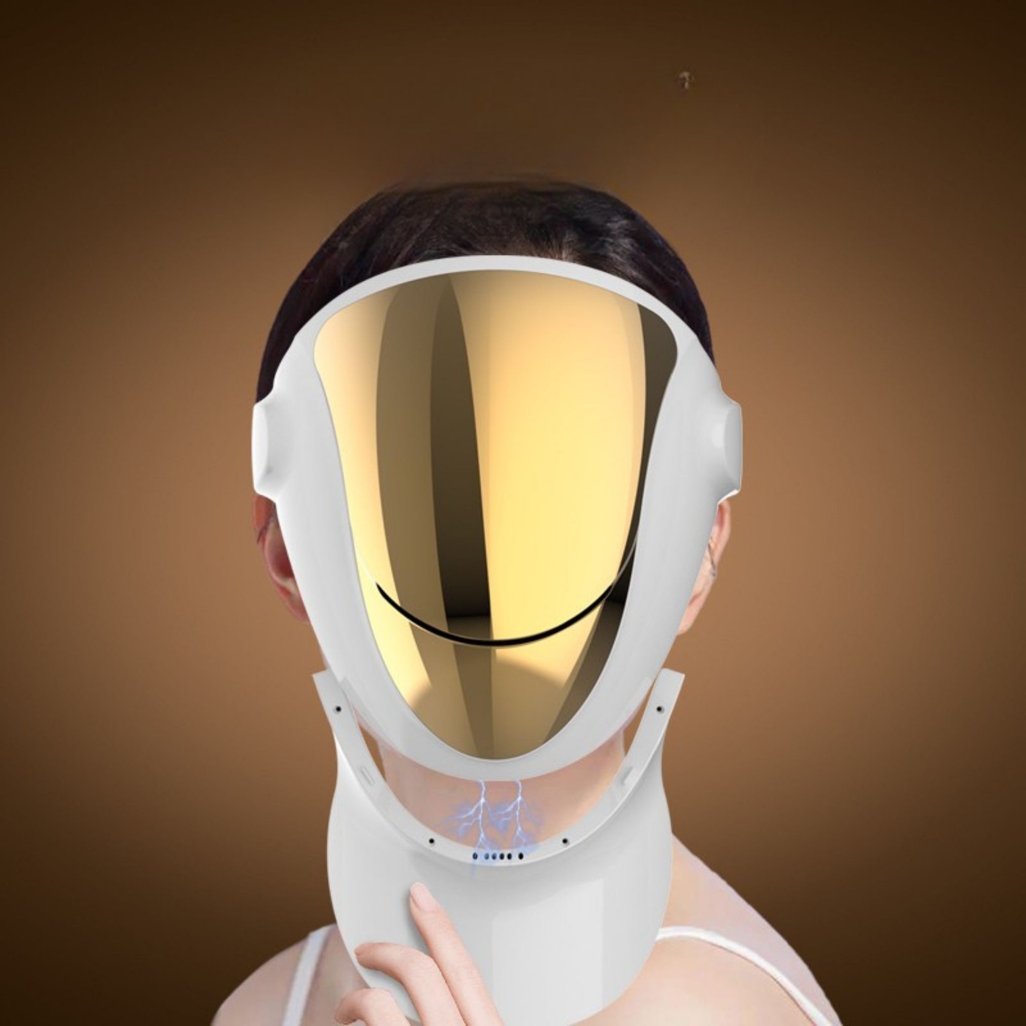 Gesichtsmaske mit goldfarbener Oberfläche und Halsansatz. Weißes Gehäuse, getragen von einer Person. Sichtbare Träger.